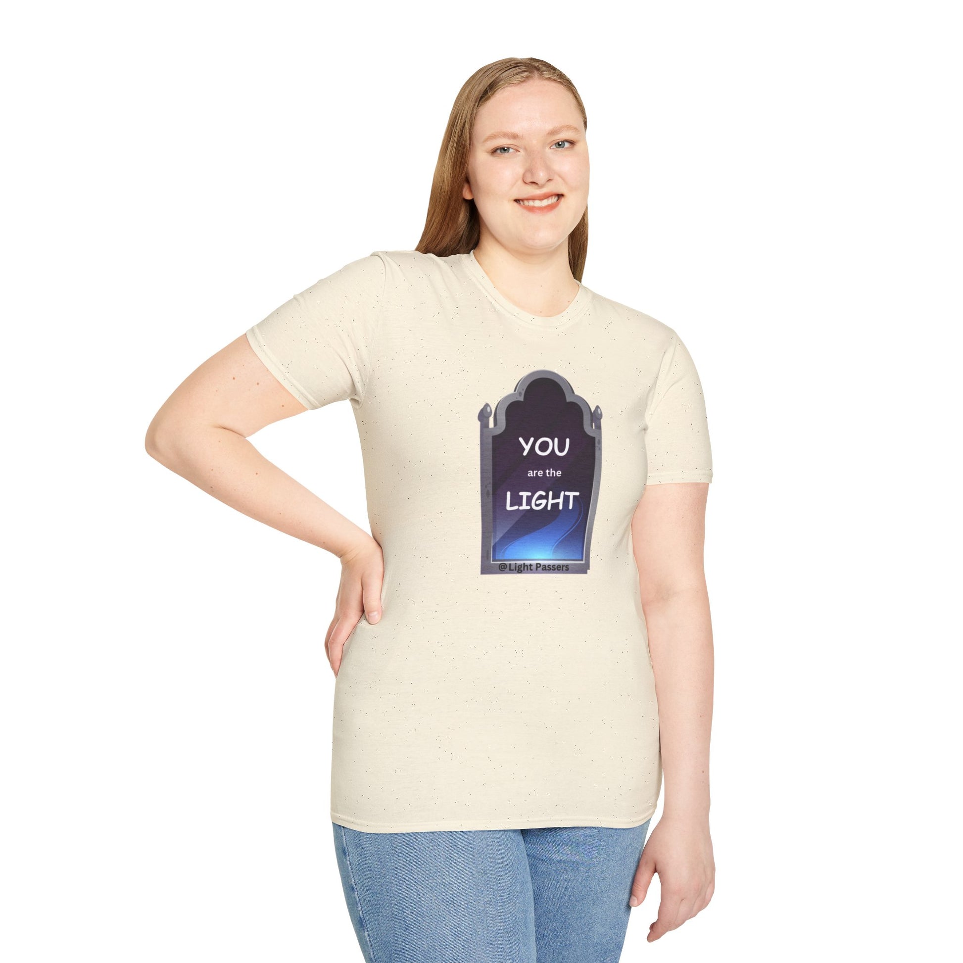 A woman in a white shirt with a graphic smiles, showcasing the Light Mirror Unisex T-shirt. Close-up of blue jeans. Casual, 100% cotton tee with no side seams for comfort.