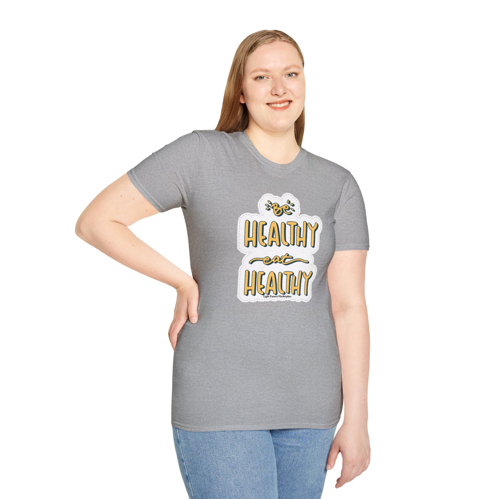 A woman in a grey Be Healthy Eat Healthy Unisex T-Shirt, showcasing a casual, comfortable style. Made of soft 100% cotton, featuring twill tape shoulders for durability and ribbed collar for a clean look.