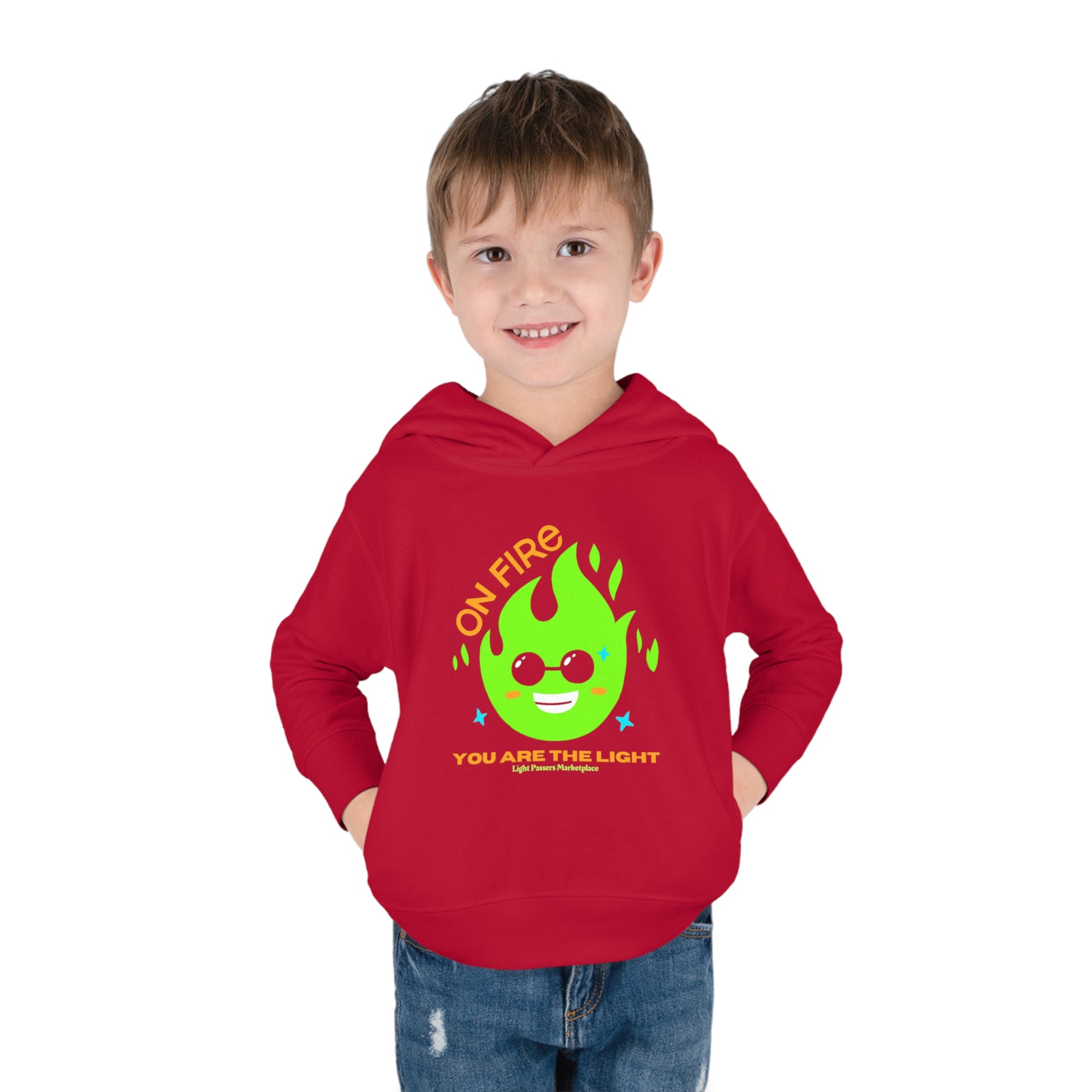 A toddler in a red Rabbit Skins hoodie with logo, side seam pockets, and cover-stitched details for durability and comfort.