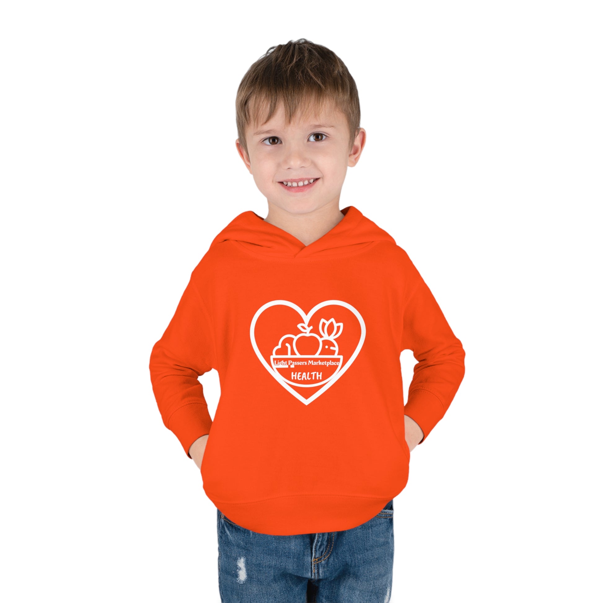 A toddler boy in a Fruit Basket Toddler Hoodie, featuring a heart and logo design, jersey-lined hood, side-seam pockets, and durable stitching for lasting coziness.