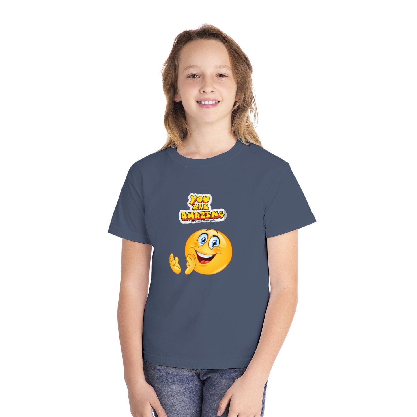 A girl in a blue You are Amazing Clap youth t-shirt, smiling. Made of 100% combed ringspun cotton, soft-washed, garment-dyed, with a classic fit for comfort and agility.