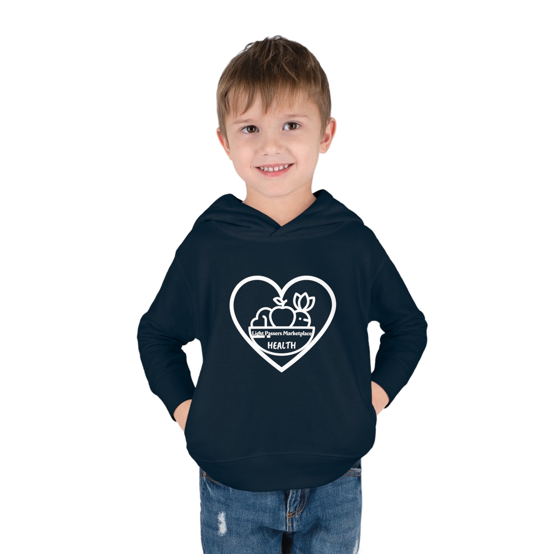 A smiling toddler in a Fruit Basket Toddler Hoodie with hands in pockets. Features jersey-lined hood, cover-stitched details, and side-seam pockets for lasting coziness.