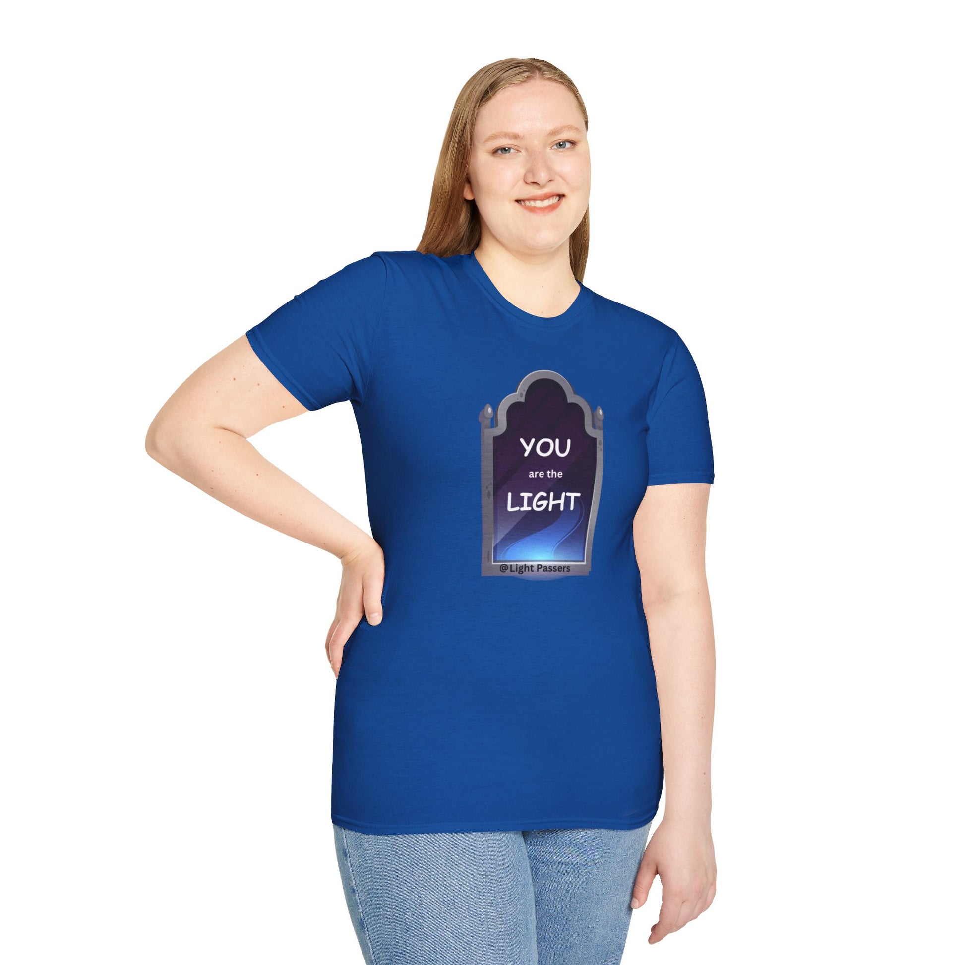 A woman in a blue shirt, smiling, poses for a picture, showcasing the Light Mirror Unisex T-shirt. Close-up of jeans visible. Casual, 100% cotton tee with no side seams for comfort.