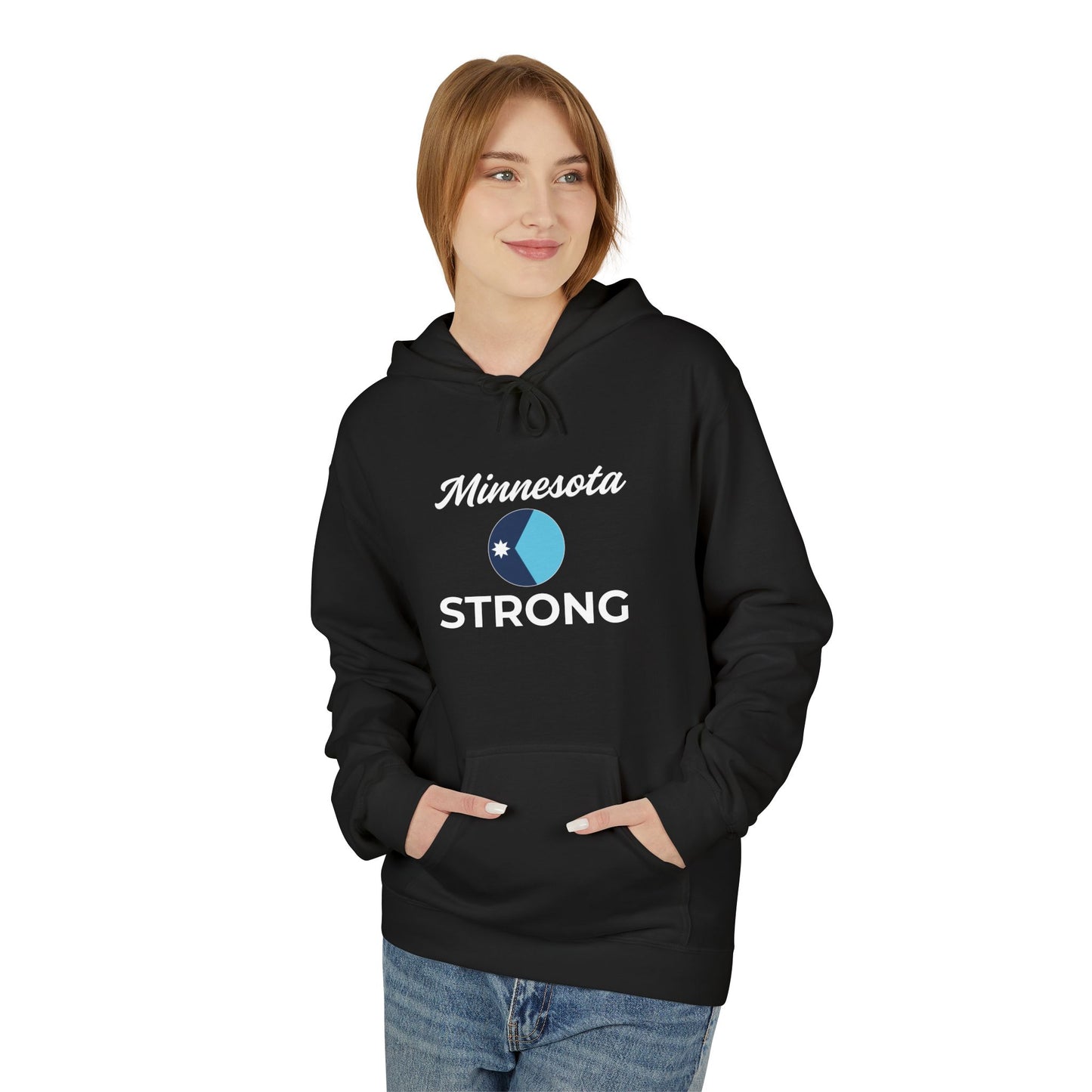 Young woman in a black Minnesota Strong hoodie with a circular graphic, embodying cozy community pride. Hands in pocket, against a white background.