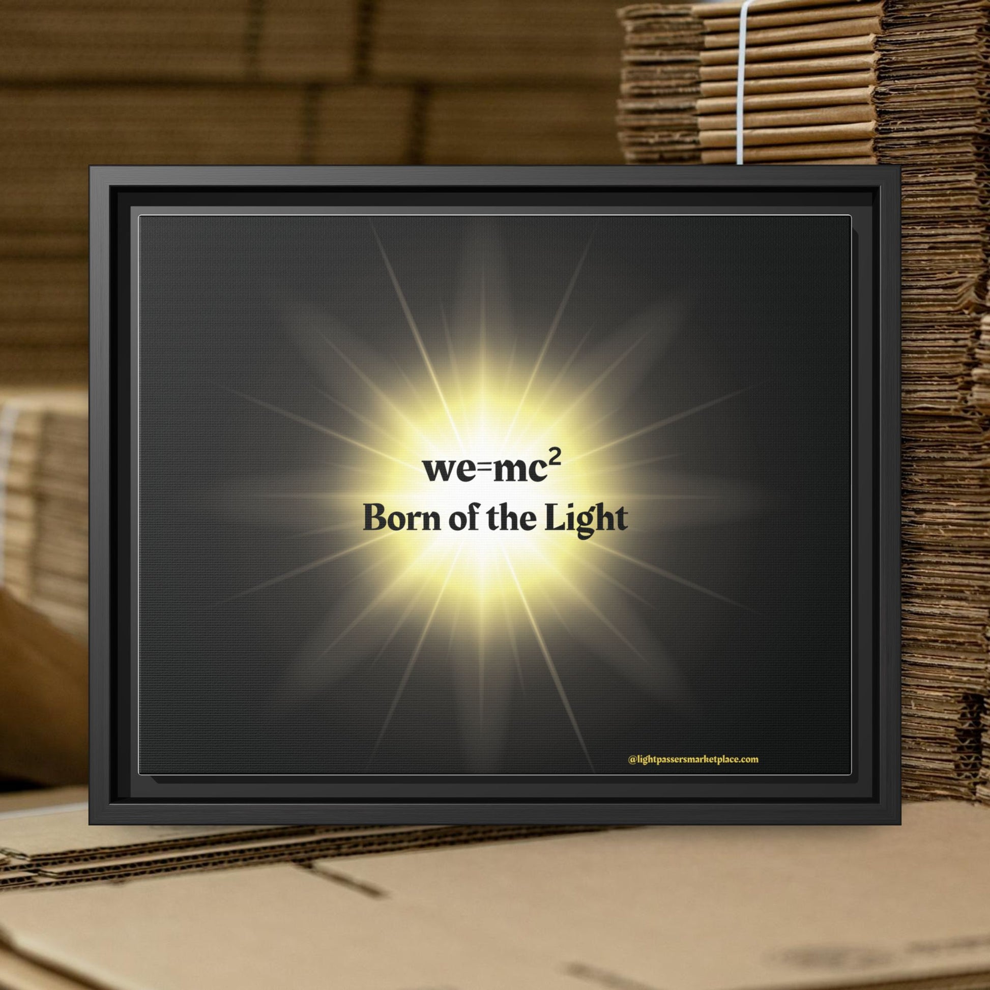 Inspirational Framed Canvas Art - we=mc² Born of the Light, showcasing a sleek black frame with a light accentuating its motivational design.