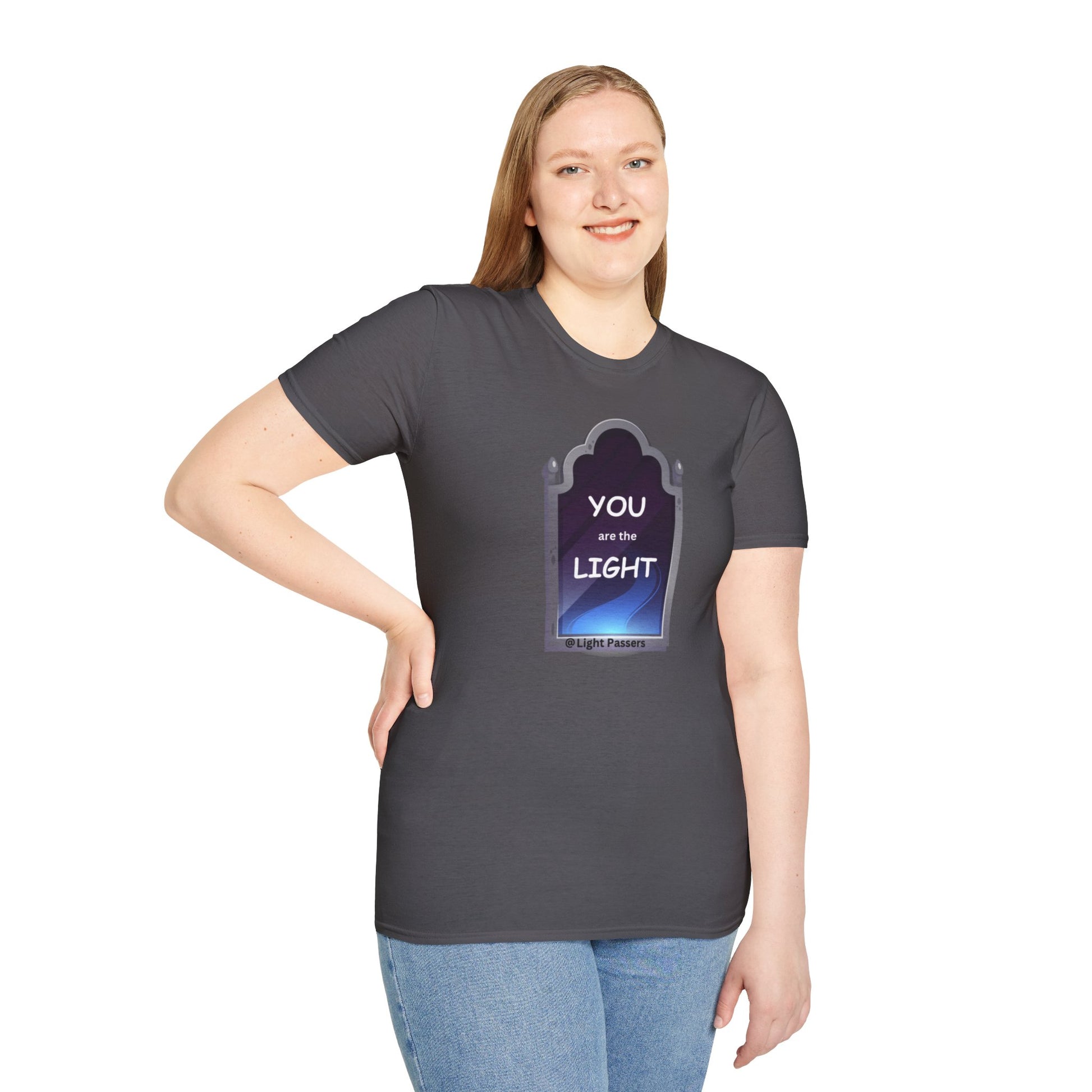 A woman in a grey shirt, smiling, poses for a picture wearing the You are the Light Mirror Unisex T-shirt. Close-up of blue jeans. Casual fashion staple with smooth surface for vivid printing.