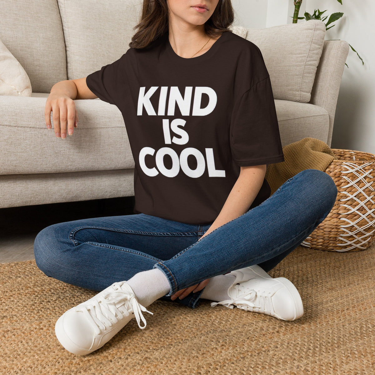 Dark brown unisex T-shirt with large text graphic reading “KIND IS COOL”