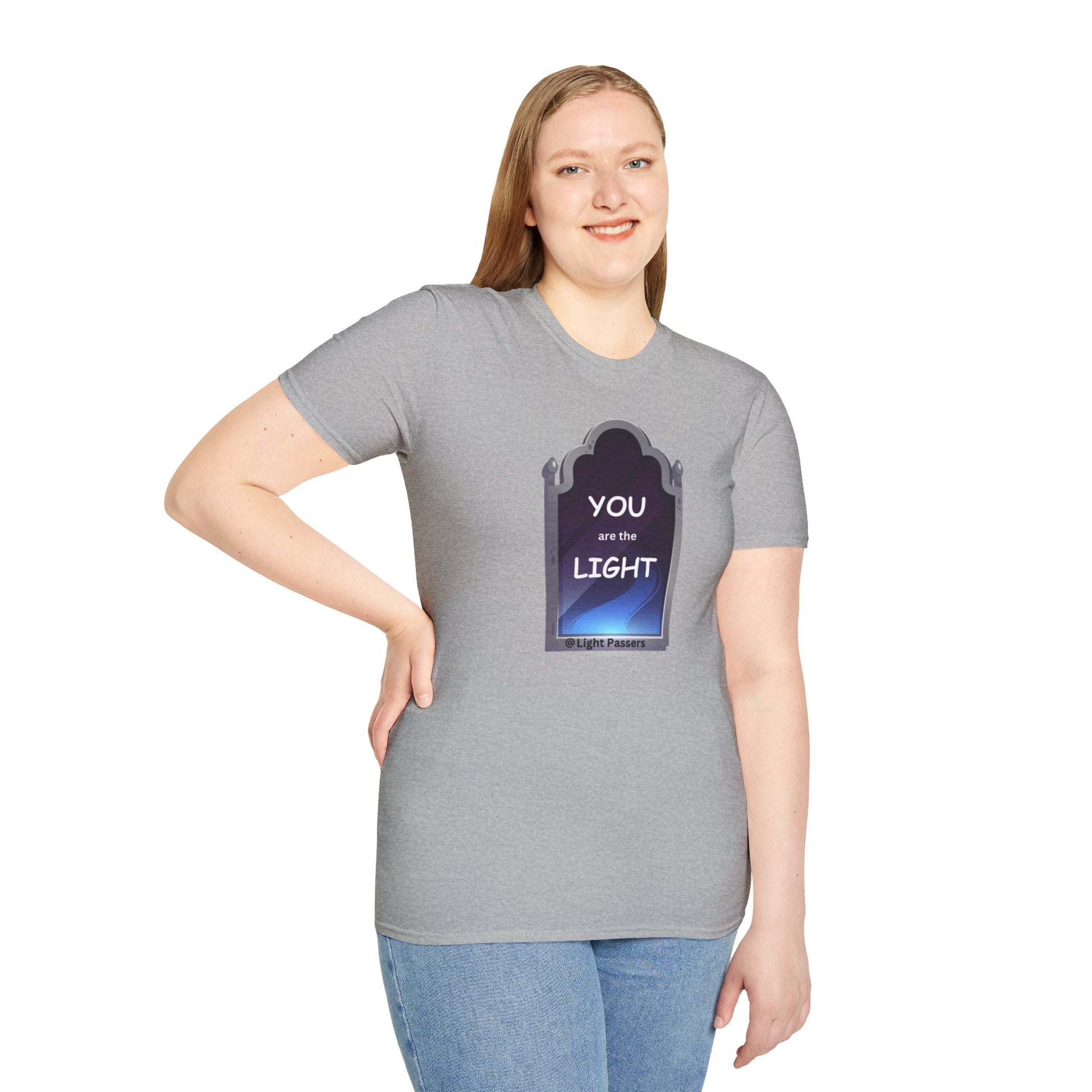 A woman in a grey shirt, smiling, poses for a picture, showcasing the Light Mirror Unisex T-shirt. Close-up of jeans and sign. Casual, durable tee for vibrant prints.