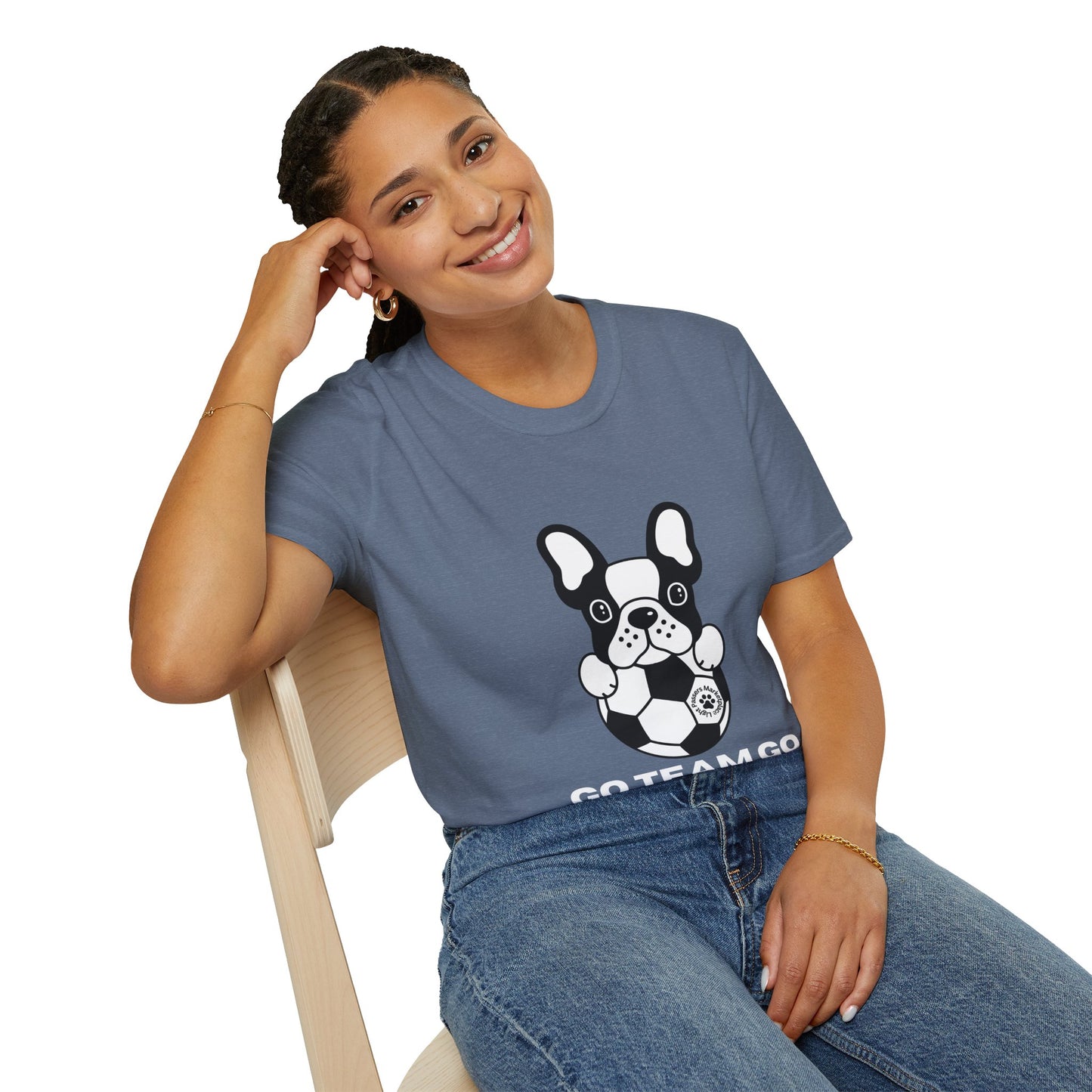 Young woman wearing the Soccer Dog Unisex T-Shirt, featuring a cartoon bulldog with soccer ball and GO TEAM GO text. Paired with blue jeans and minimal jewelry.