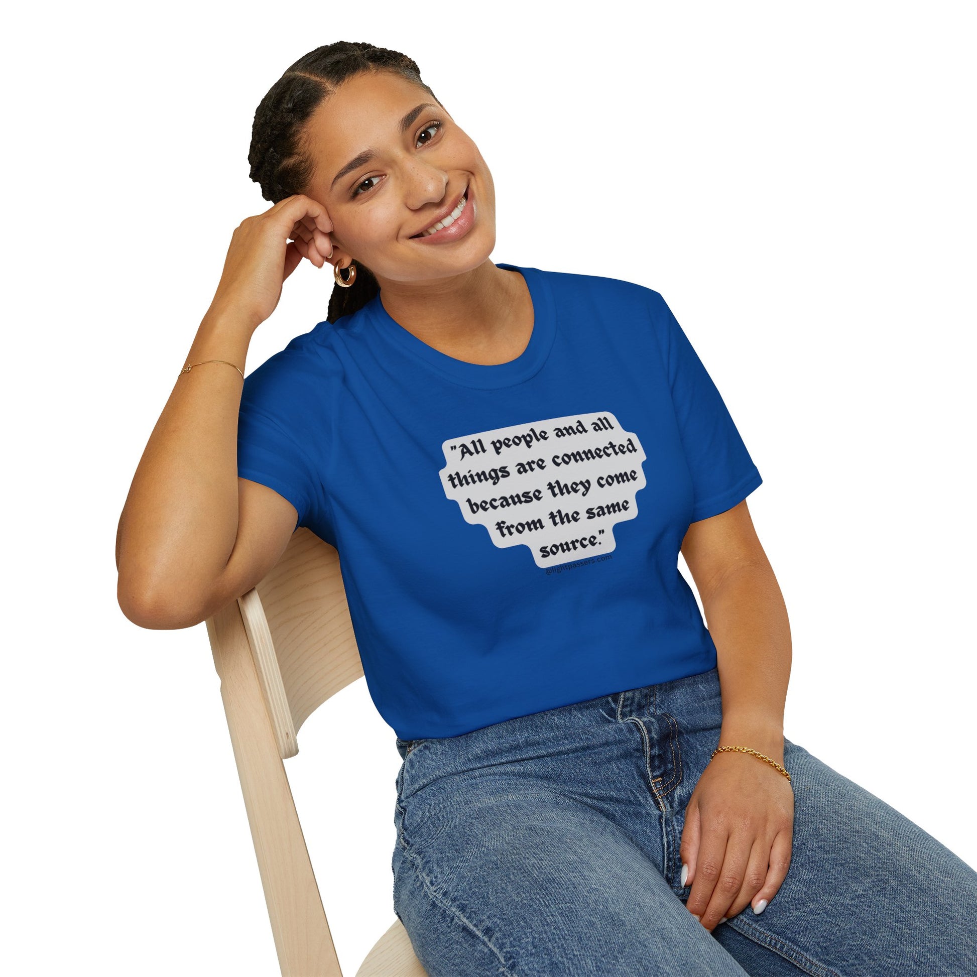 A woman in a blue shirt sits on a chair, smiling with her hand on her head, showcasing the All People are Connected Gray Unisex T-shirt.