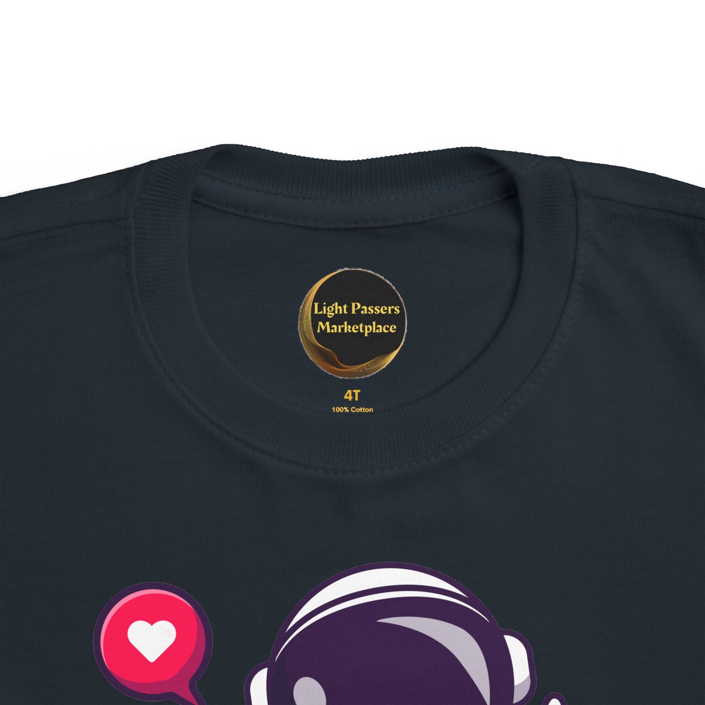 Peace Astronaut Toddler T-shirt neckline with Light Passers Marketplace logo, featuring purple astronaut and red heart graphics, crafted for toddler comfort.