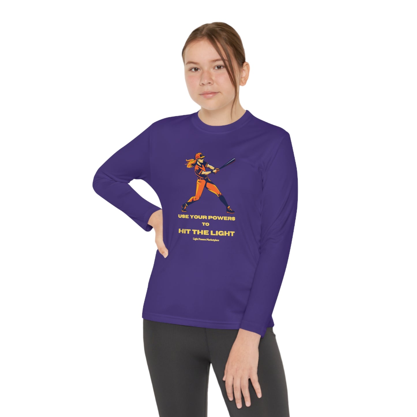 A girl in a purple long-sleeve tee swings a baseball bat, embodying active comfort. Made of 100% moisture-wicking polyester with an athletic fit and tear-away label for active kids.