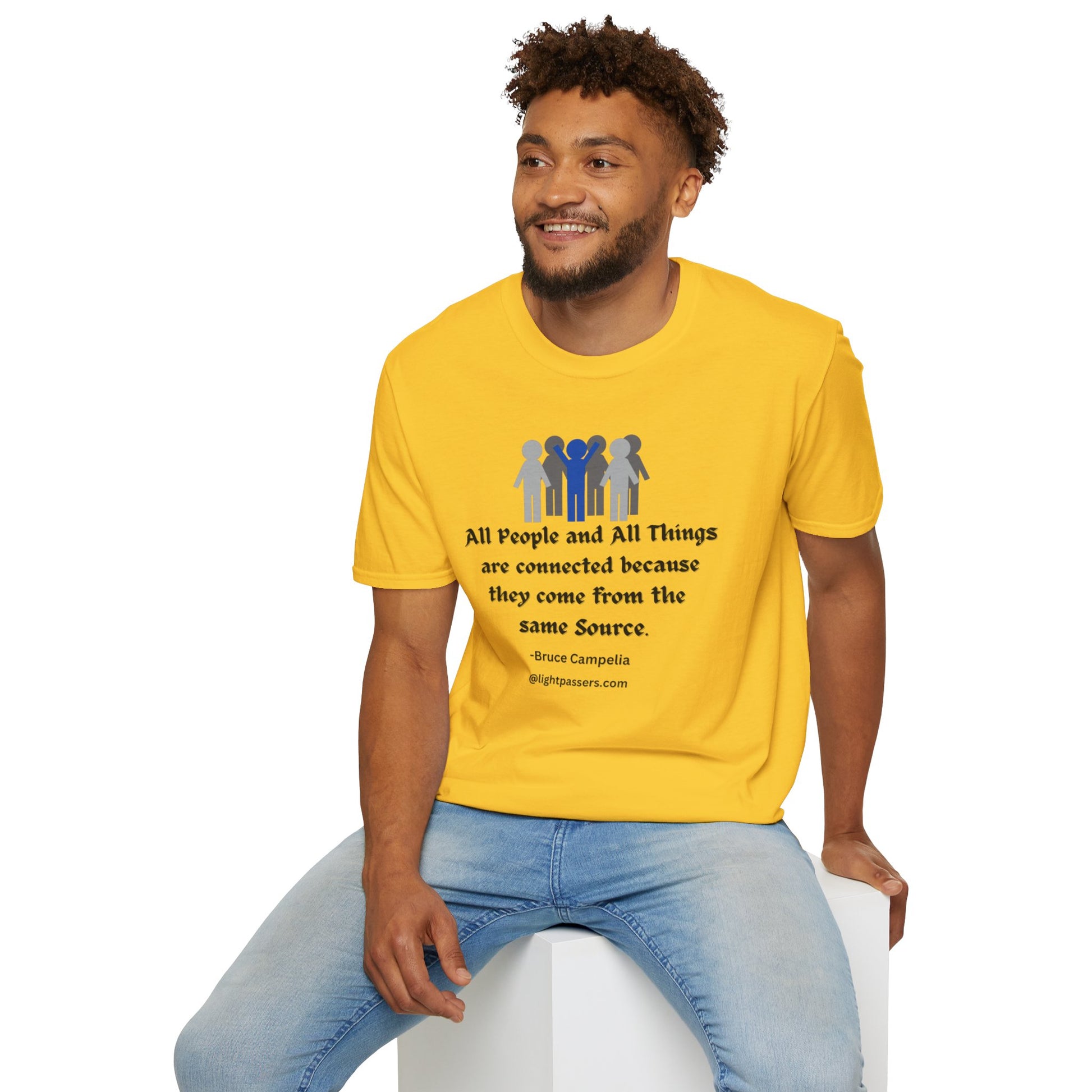 A man in a yellow shirt sits on a cube, showcasing the All People are Connected Gray and blue design Unisex T-shirt. The image features a person in casual attire, emphasizing the tee's versatile style.