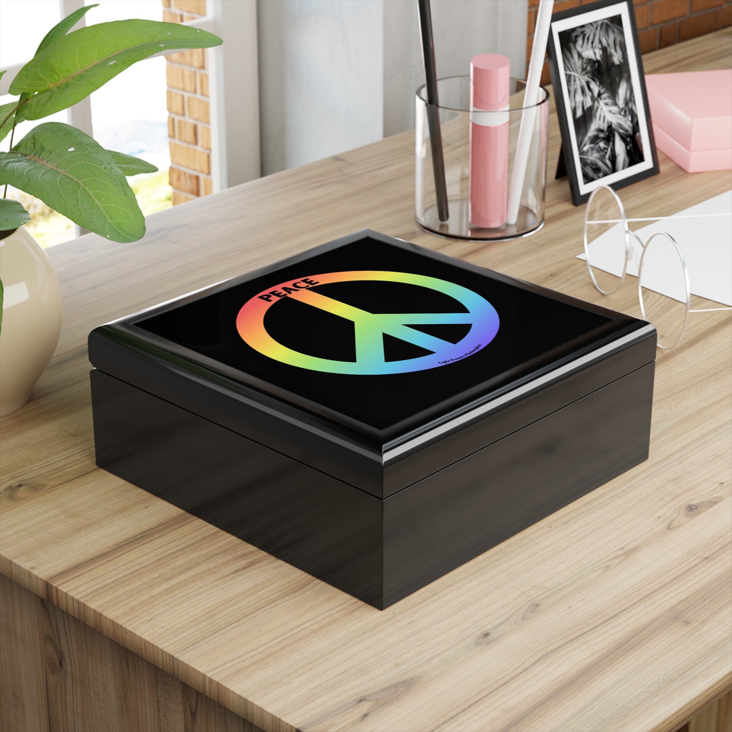 Peace Sign Small Jewelry Box on desk, featuring glossy lid with peace symbol, surrounded by potted plant, pen cup, photo frame, and eyeglasses.