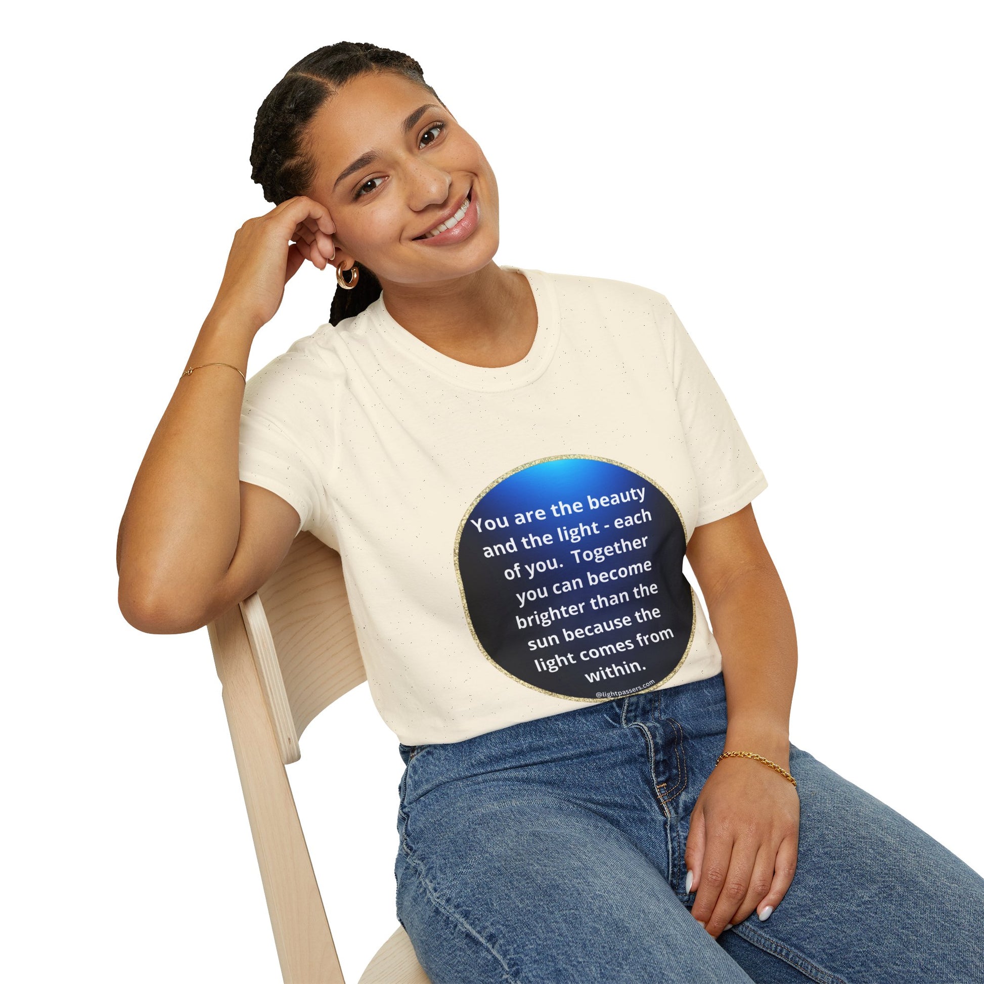 A woman in a white shirt and blue jeans sits on a chair, smiling. The image features a close-up of a hand and a blue circle with white text. Unisex heavy cotton tee with smooth surface for vivid printing.