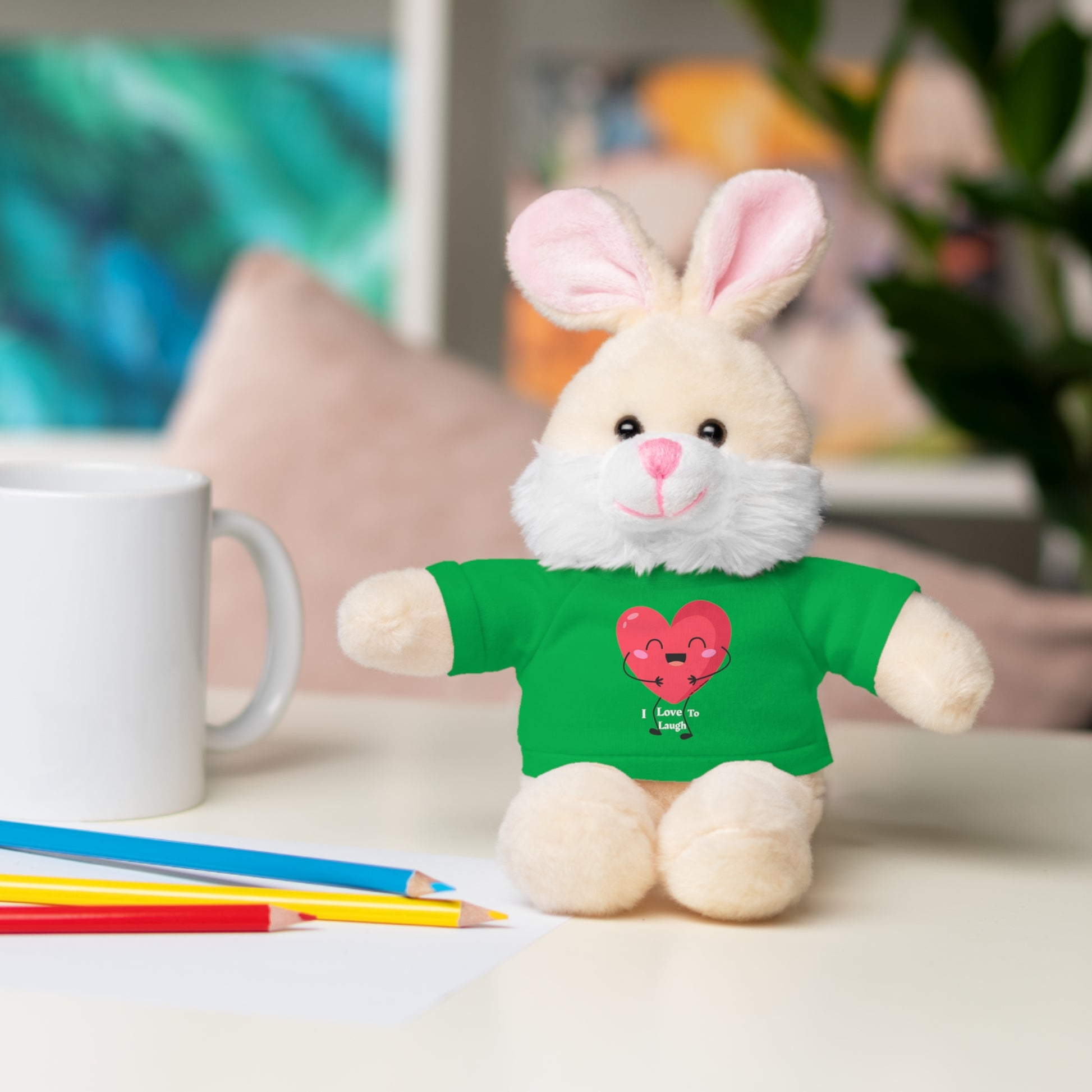 Cool Stuff Stuffies Choice of 6 Animals I Love to Laugh Heart Removable T-shirt featuring a plush bunny in a green shirt on a table.