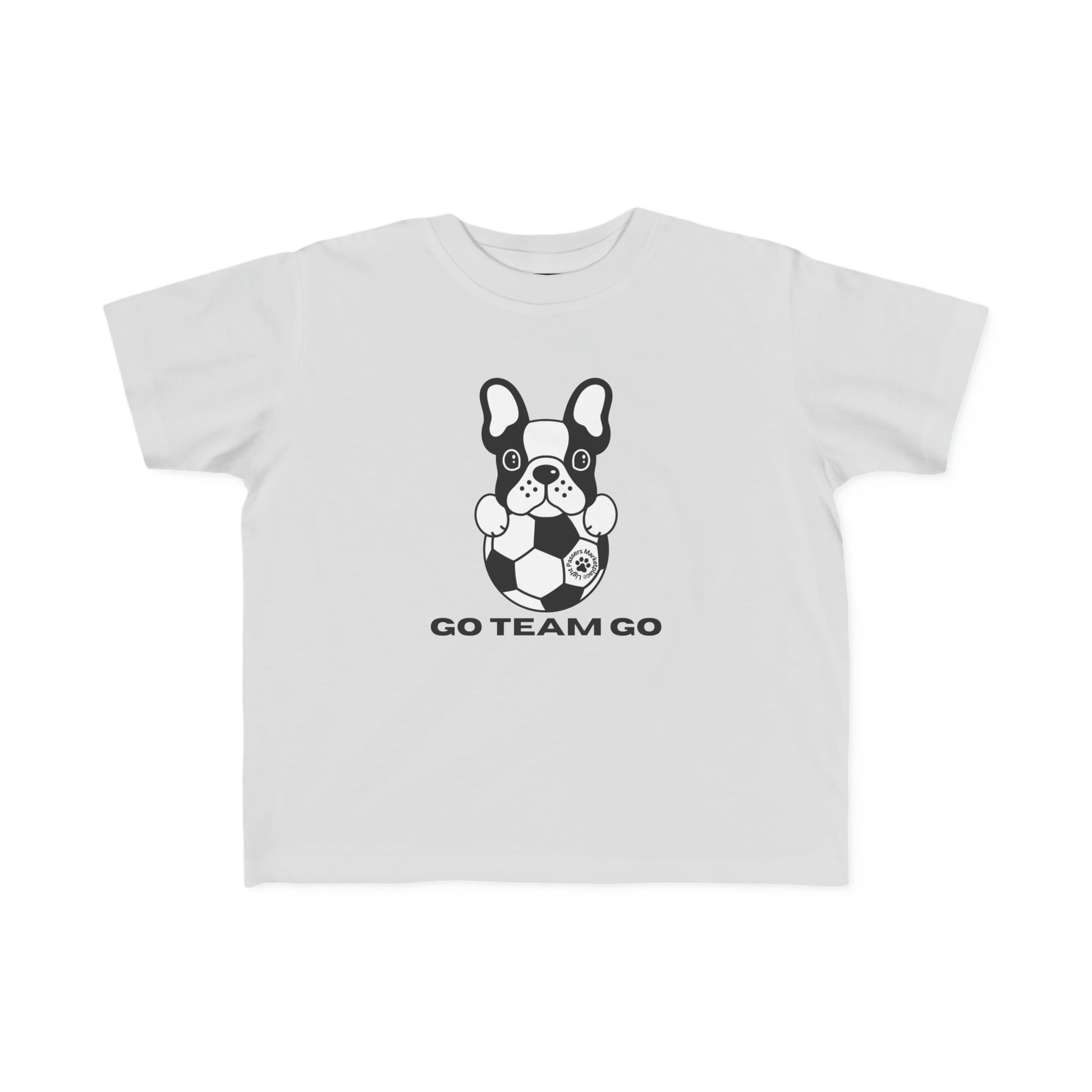 A toddler's white tee featuring a dog playing soccer, emphasizing softness and durability. Made of 100% combed cotton, light fabric, and a tear-away label for comfort.