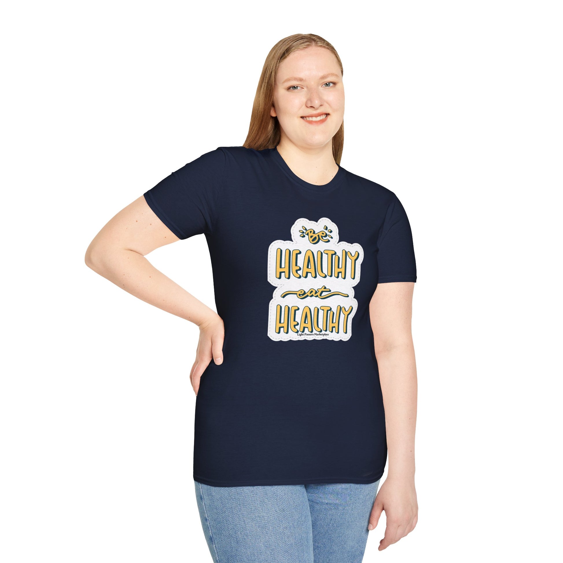 A woman in a blue shirt smiles, posing for a picture. Close-up of jeans. White and yellow sign. Be Healthy Eat Healthy Unisex T-Shirt, 100% cotton, twill tape shoulders, no side seams, ribbed collar.