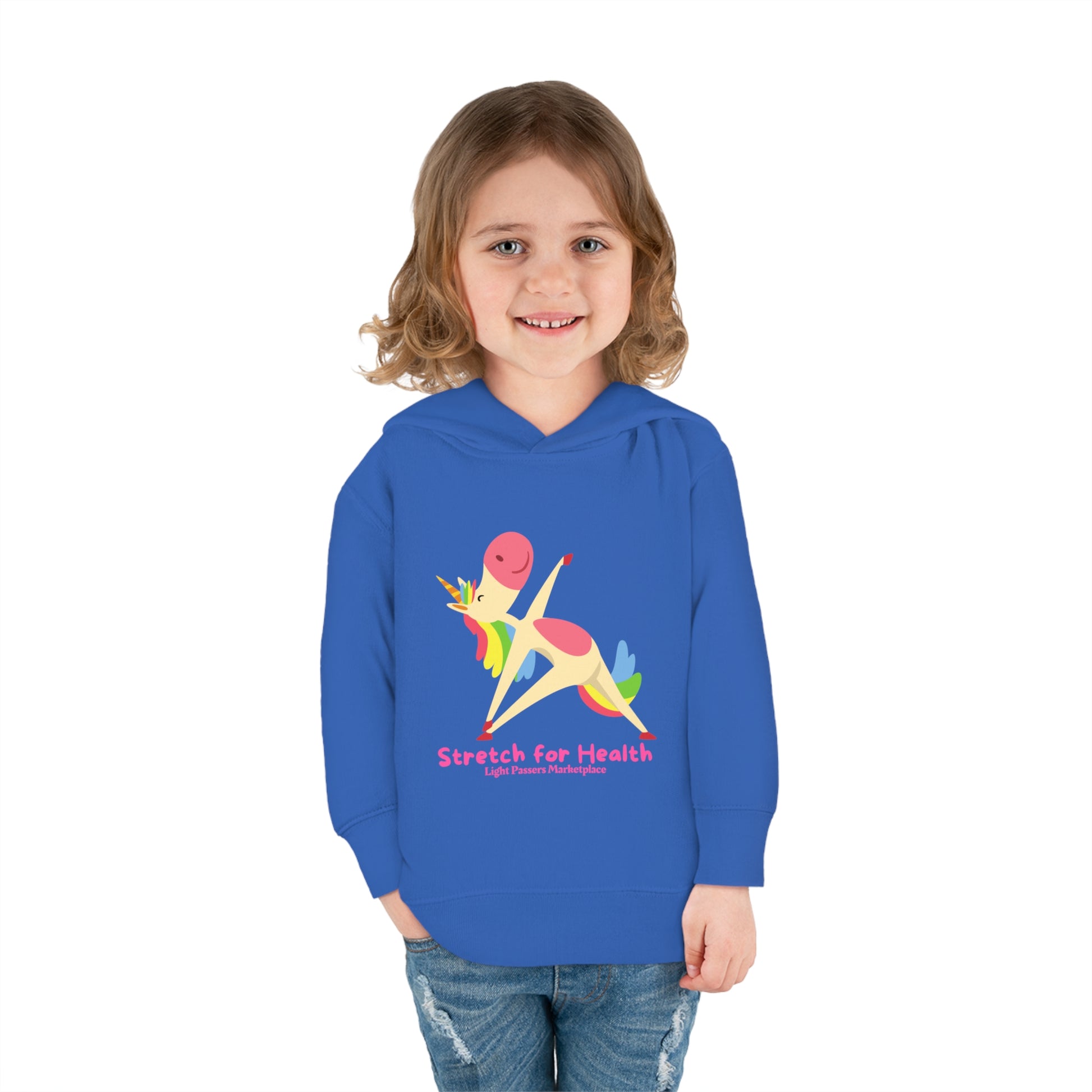 A smiling child in a Unicorn Stretch Toddler Hoodie with jersey-lined hood, cover-stitched details, and side seam pockets for durable coziness.