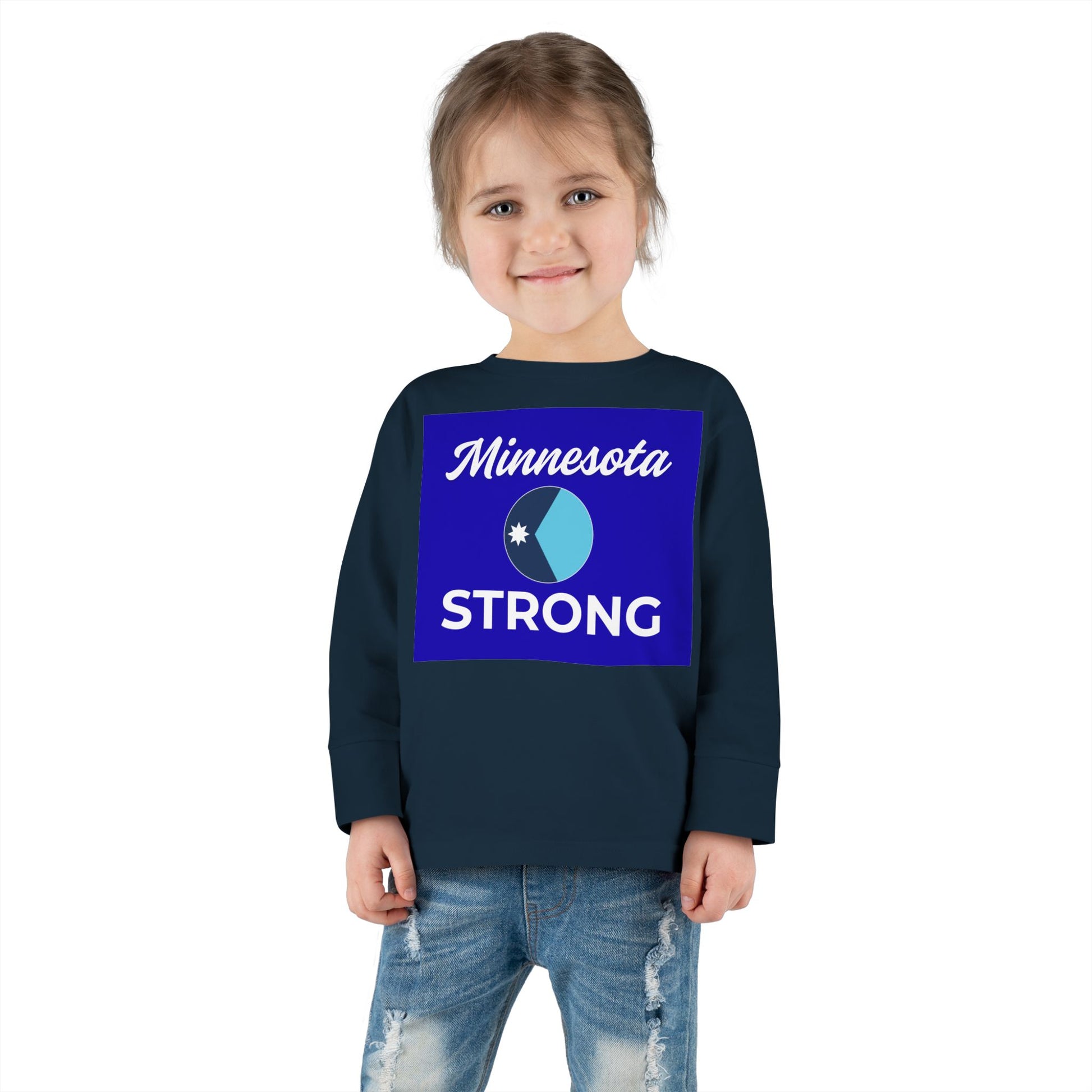 Child wearing Minnesota Strong long-sleeve tee, featuring blue graphic and star emblem, paired with light-wash jeans, embodying community pride.