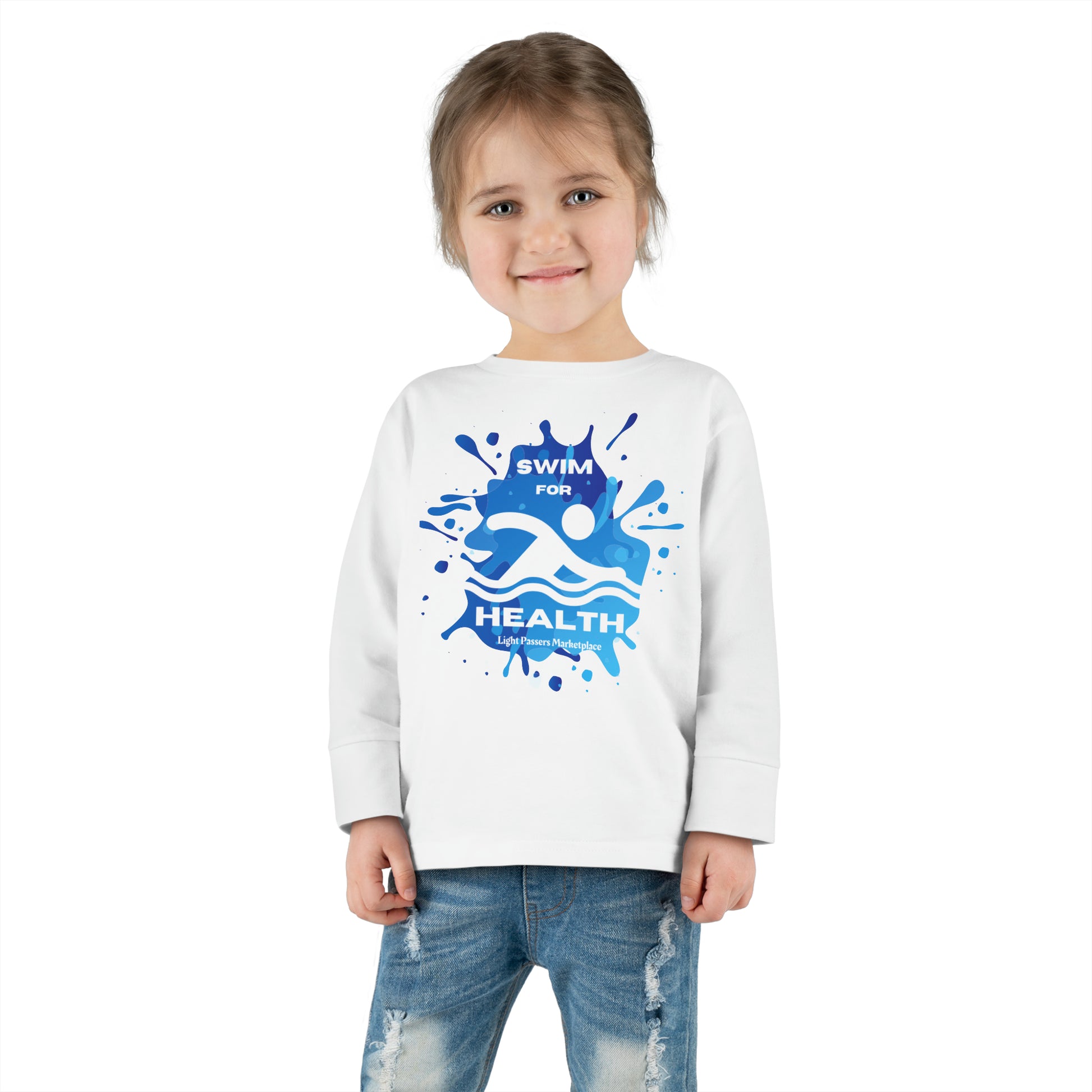 A toddler wearing a white long-sleeve tee with blue paint splashes, featuring a ribbed collar and tear-away label for comfort and durability.