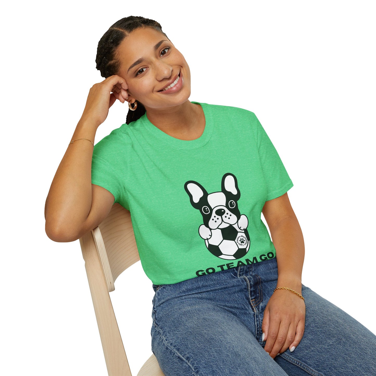 Young woman in casual blue jeans and a bright green Soccer Dog Unisex T-Shirt, showcasing a fun cartoon of a French bulldog with a soccer ball.
