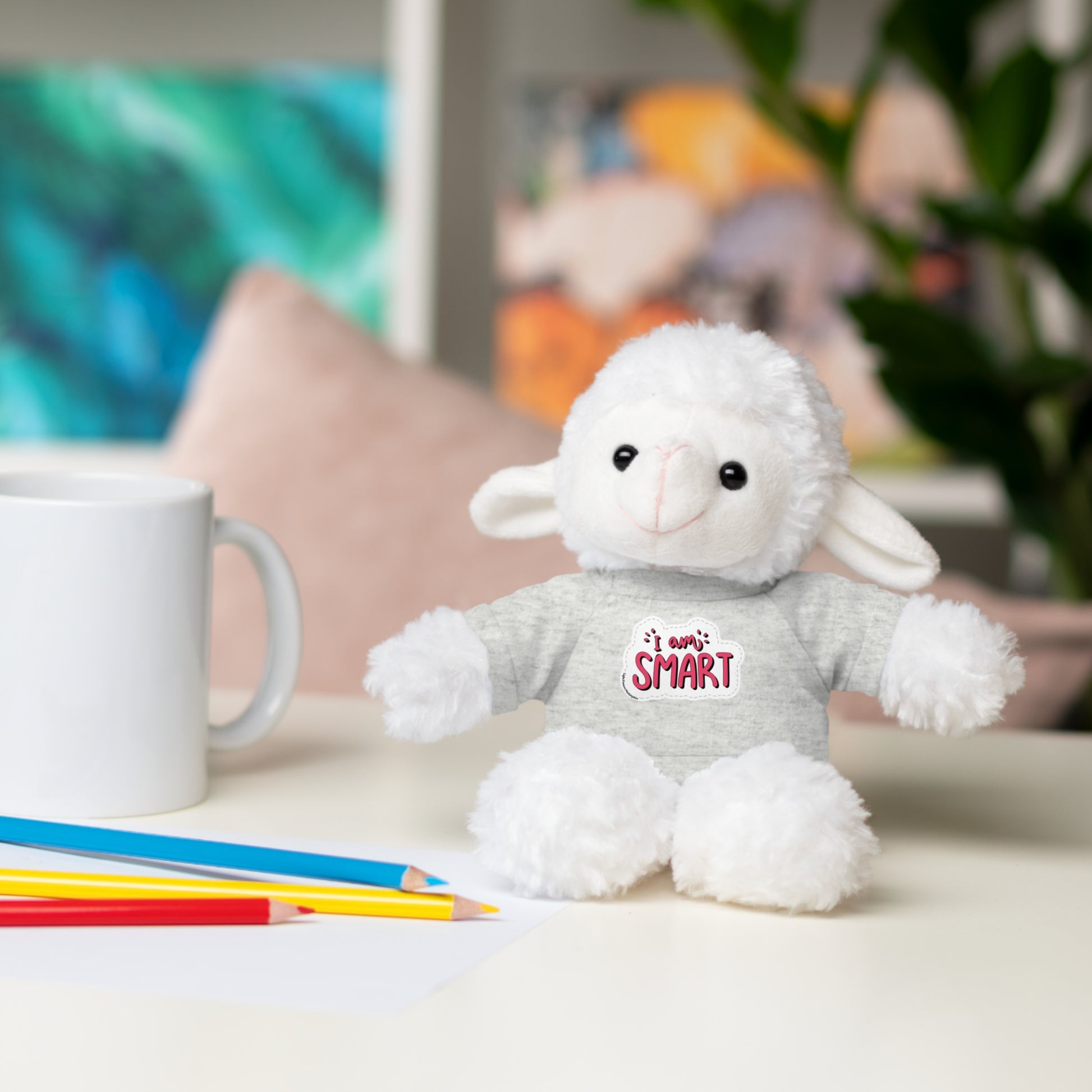 Cool Stuff Stuffies plush toy, a bunny with an 'I am Smart' T-shirt, sitting on a table next to a white mug.
