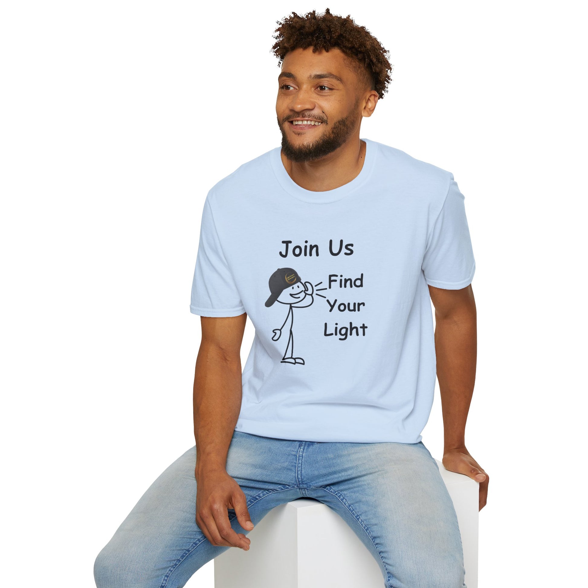 A man in a white cartoon character tee sits on a cube, showcasing the Join Us Find Your Light Unisex T-Shirt's casual comfort. Made of soft 100% cotton, with twill tape shoulders and a ribbed collar for durability.