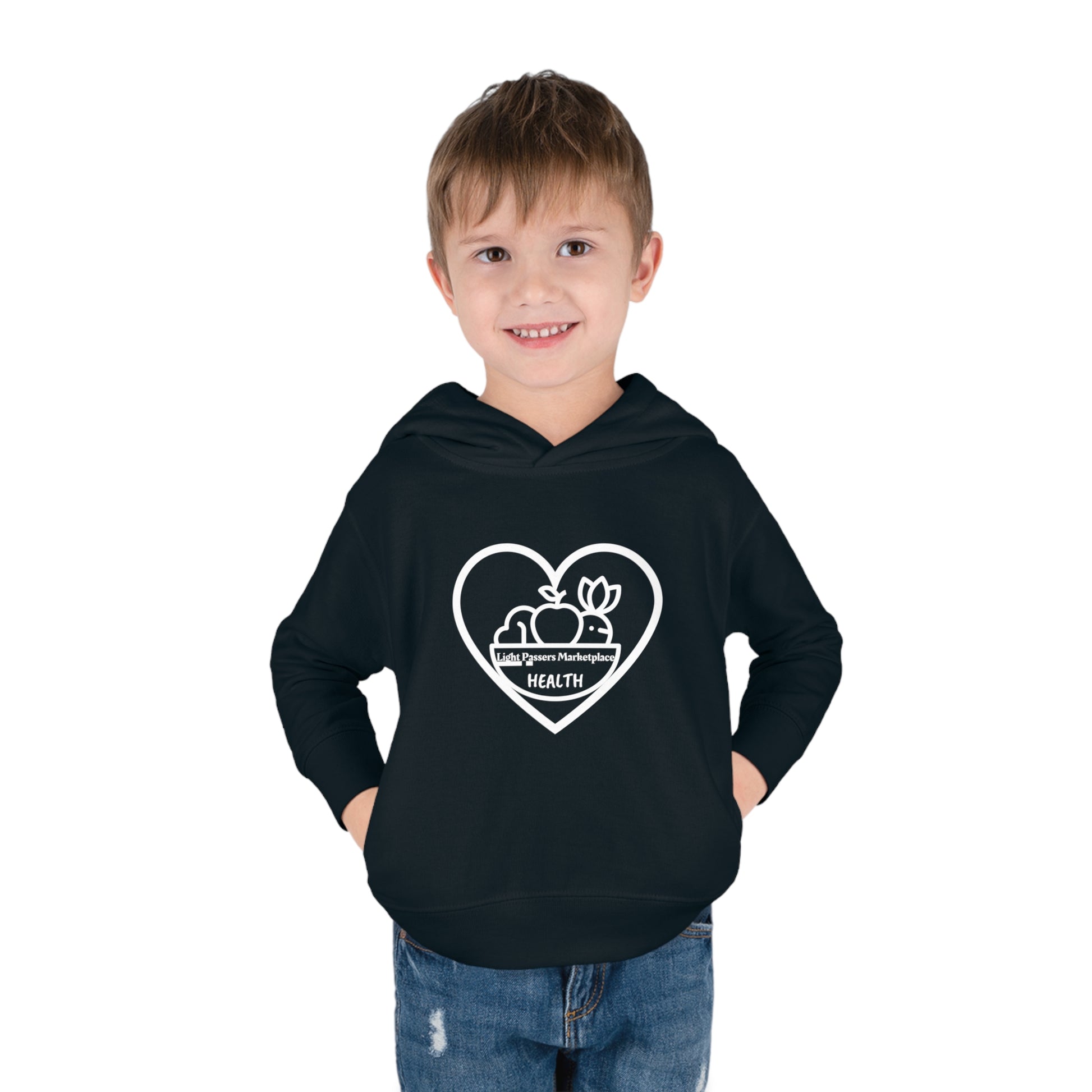 A toddler in a black hoodie with a heart and fruit logo, featuring side seam pockets and cover-stitched details for durability and comfort.