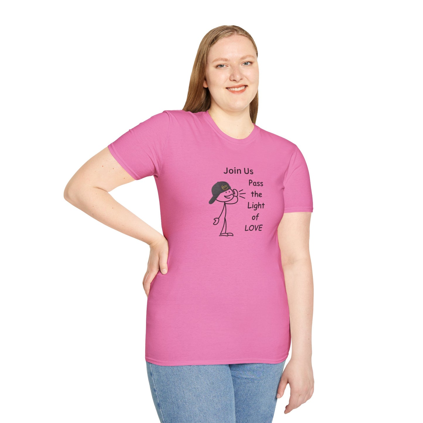 A woman in a pink shirt smiles at the camera, showcasing the Join Us Pass the Light of Love Unisex T-shirt. The image features a cartoon character, jeans, and a pink poster, embodying casual fashion with premium cotton fabric and seamless design.