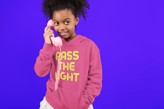 A girl in a pink telephone-themed hoodie with kangaroo pocket. Youth blend hooded sweatshirt, 50% cotton 50% polyester, soft fleece, reinforced neck, regular fit.