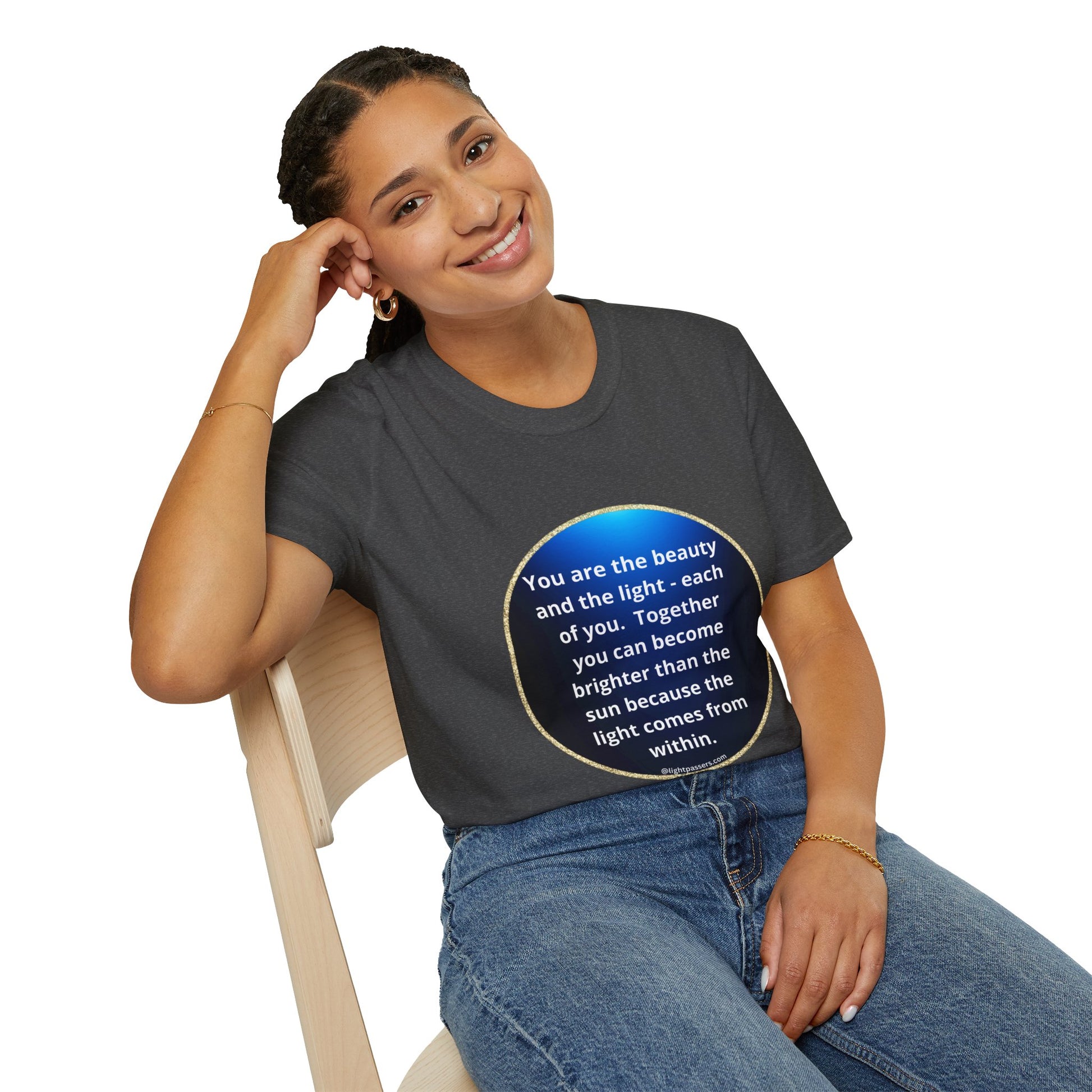 A woman in a navy circle unisex t-shirt, smiling and sitting on a chair. Close-up of her face and hand on her lap. Classic fit, 100% cotton tee for casual style.