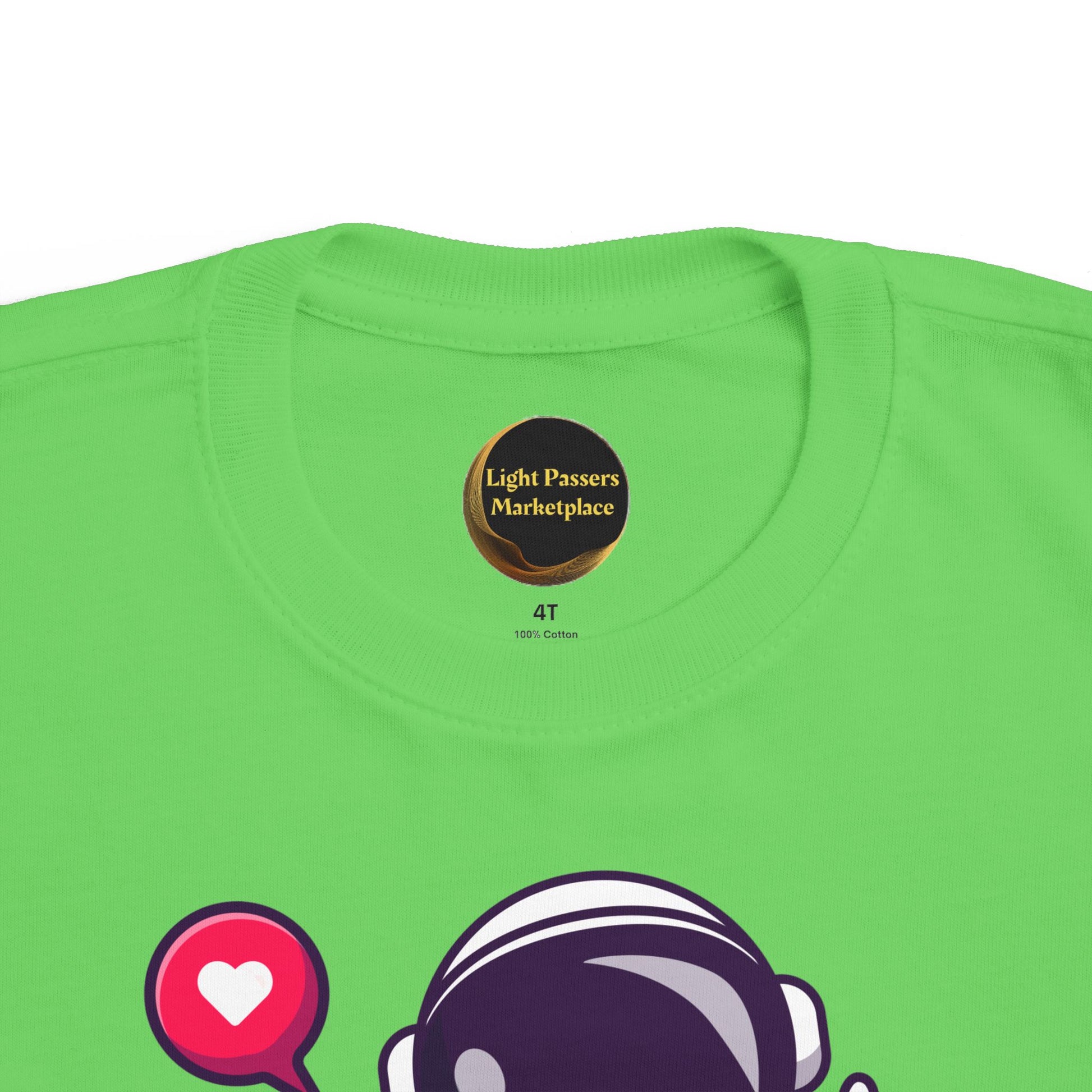 Peace Astronaut Toddler T-shirt with cartoon astronaut helmet and heart speech-bubble graphic, showcasing softness for sensitive skin; label reads Light Passers Marketplace.