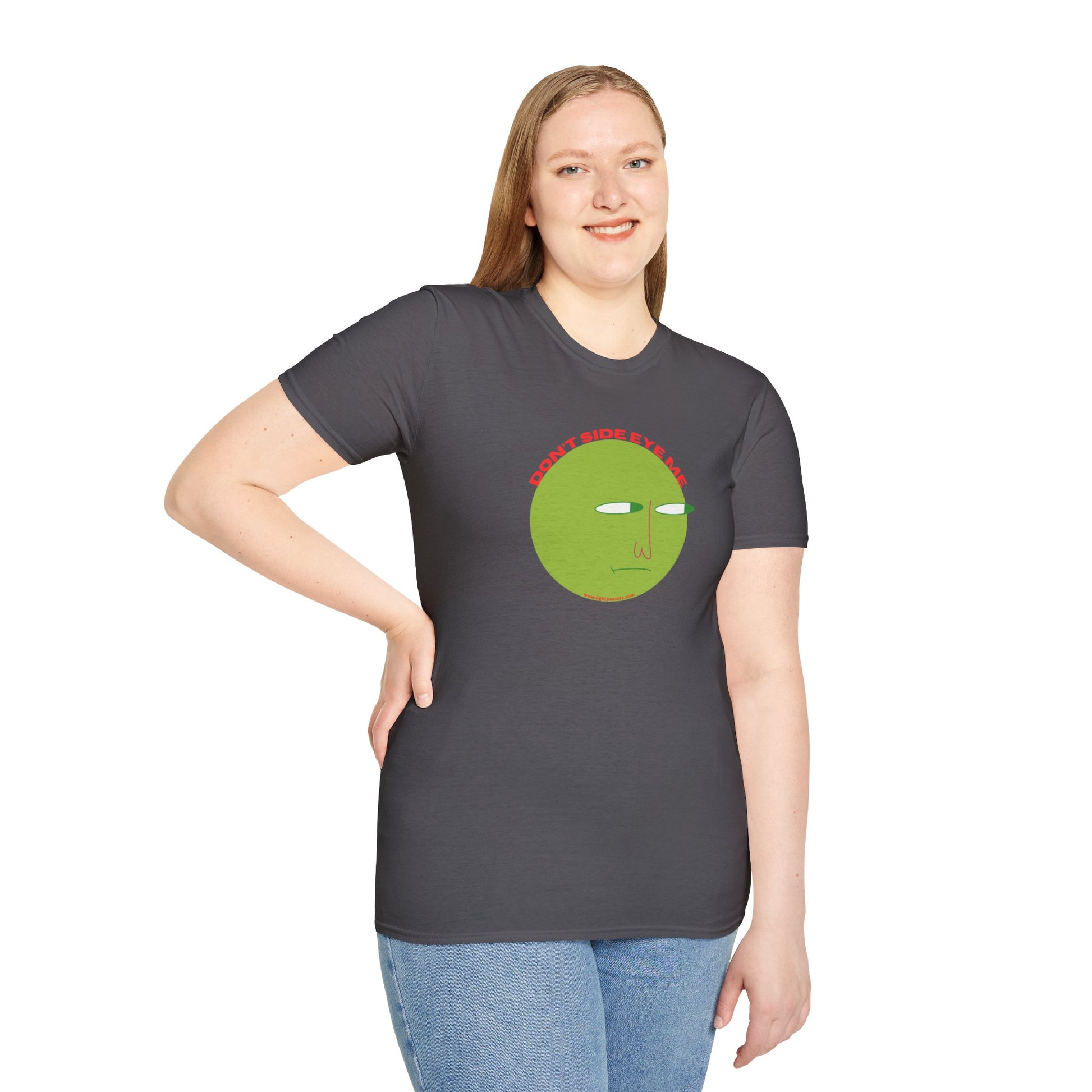 A woman in a grey shirt with a green face graphic poses, showcasing the Don't Side Eye Me unisex t-shirt. Made of soft 100% cotton, featuring twill tape shoulders and a ribbed collar.