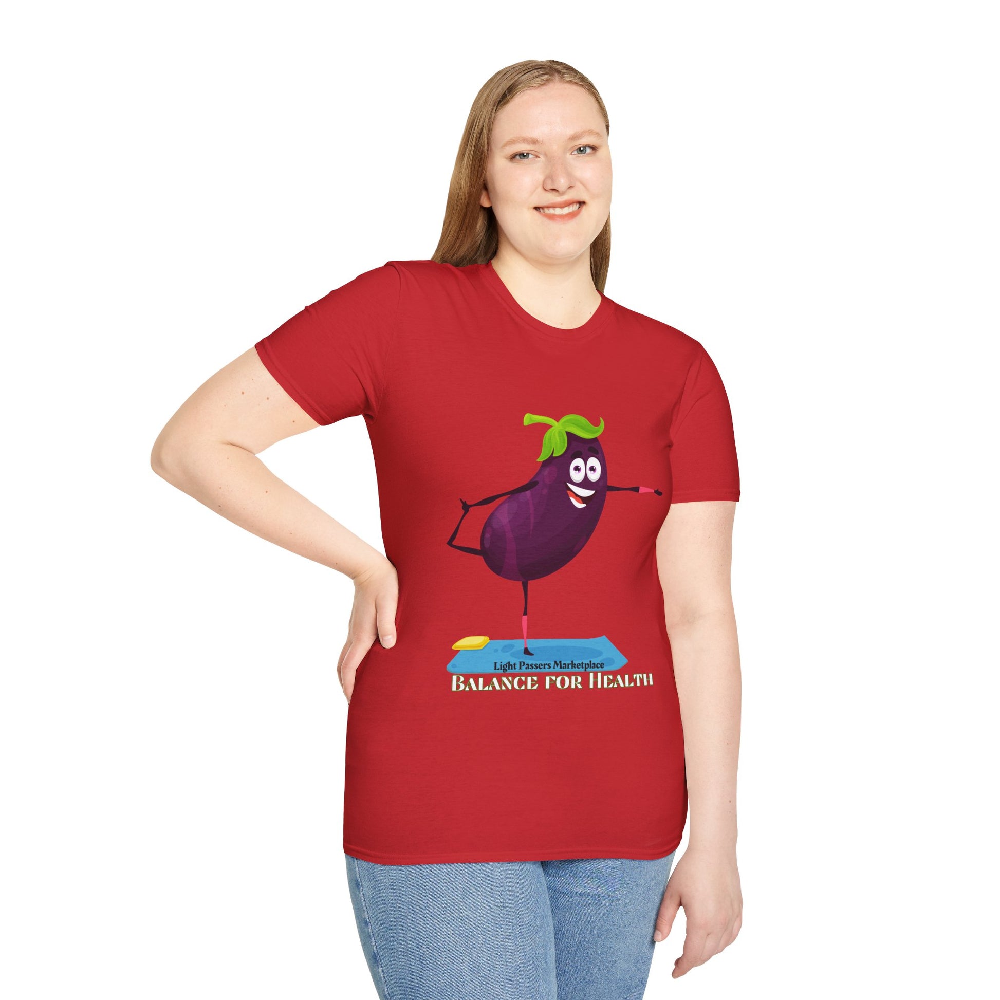 A woman in a red shirt smiles, wearing a t-shirt with a cartoon eggplant design. Unisex soft-style tee, 100% cotton, lightweight fabric, crew neckline, tear-away label, ethically sourced US cotton.