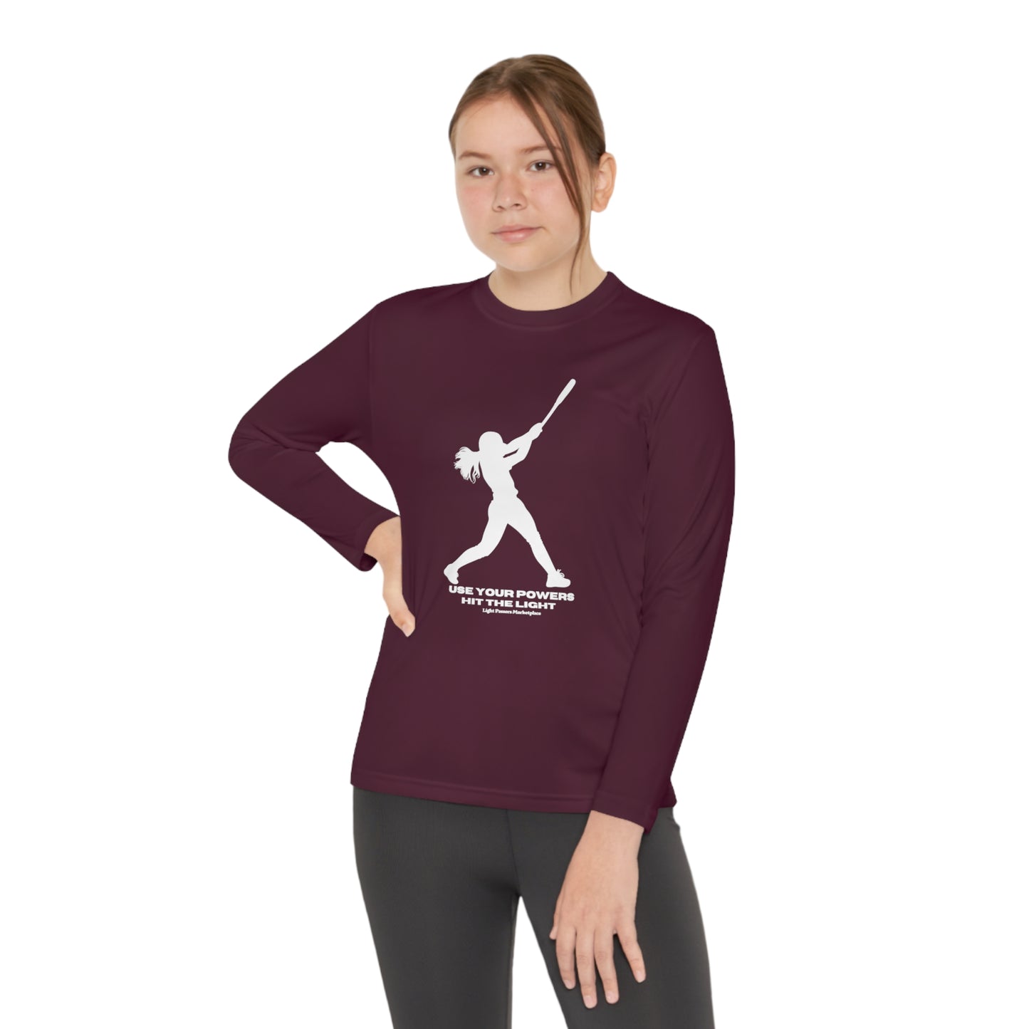 A girl in a maroon long-sleeve tee swings a bat, embodying active comfort. Made of 100% moisture-wicking polyester, lightweight, and breathable for active kids.