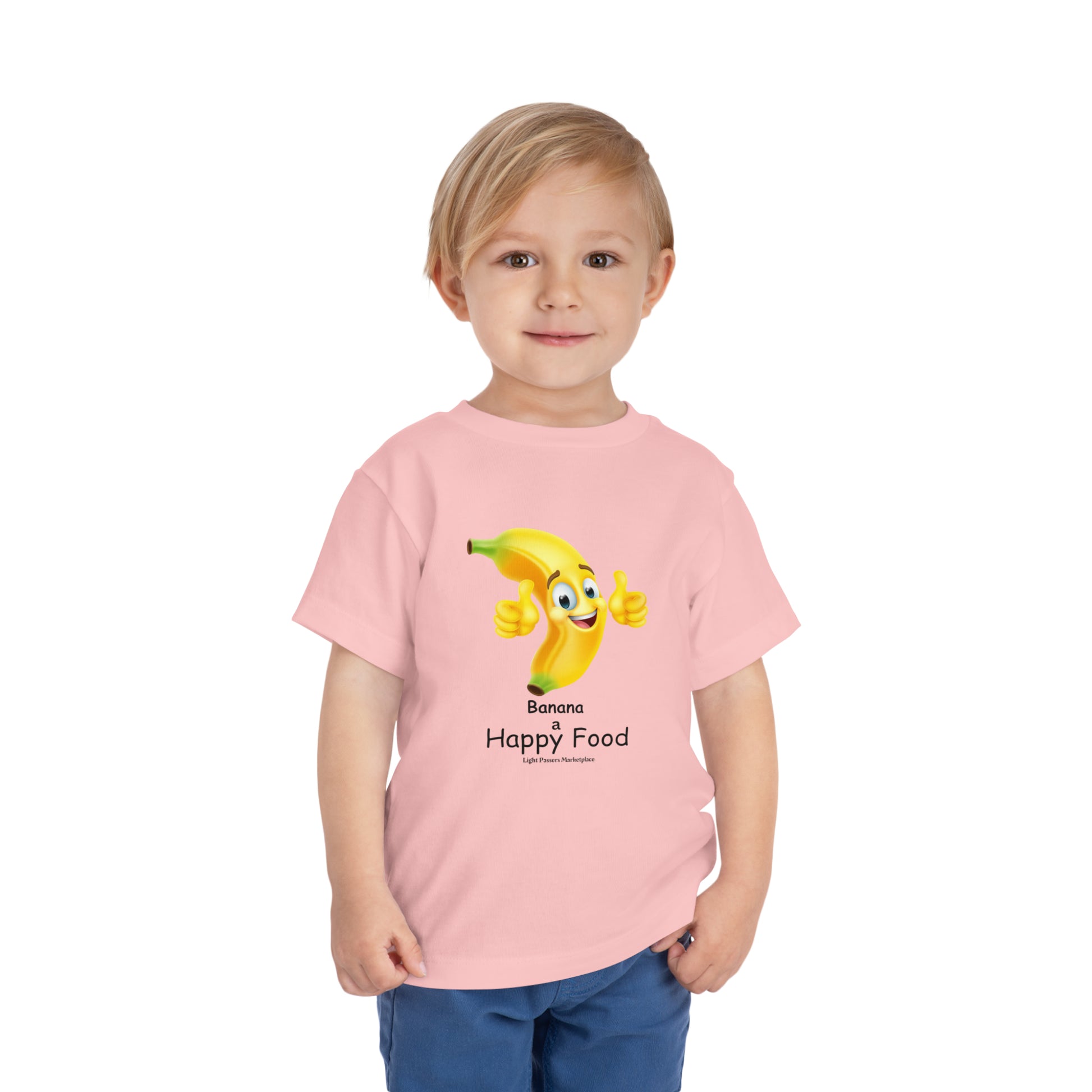 A toddler in a pink shirt, featuring a cartoon banana giving a thumbs up. Bella Canvas tee, 100% cotton, tear-away label, light fabric.