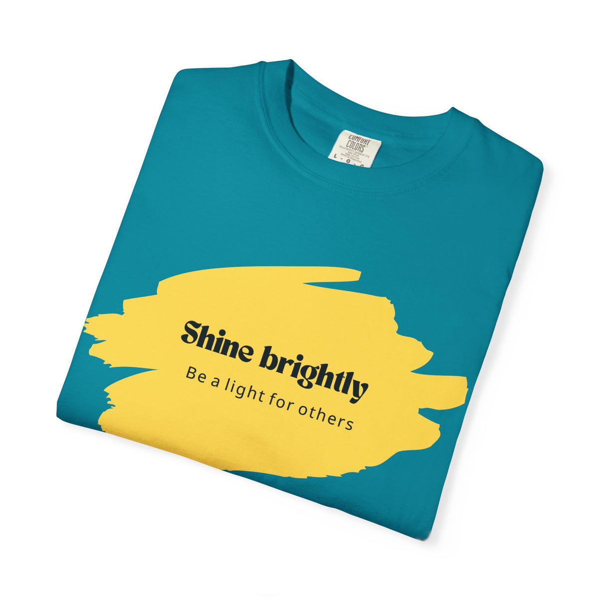 Teal unisex T-shirt with yellow “Shine brightly” graphic and crew neck.