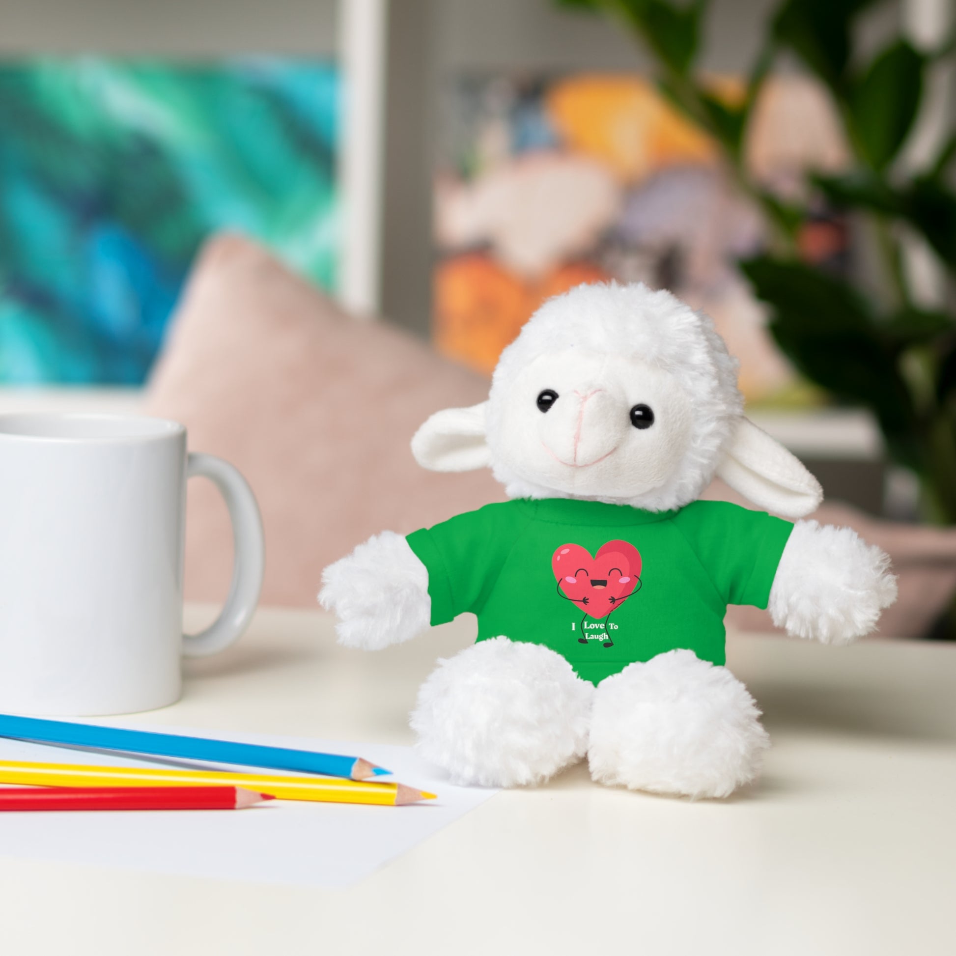 Stuffed animal in a green shirt on a table, part of Cool Stuff Stuffies collection, featuring the I Love to Laugh removable T-shirt.