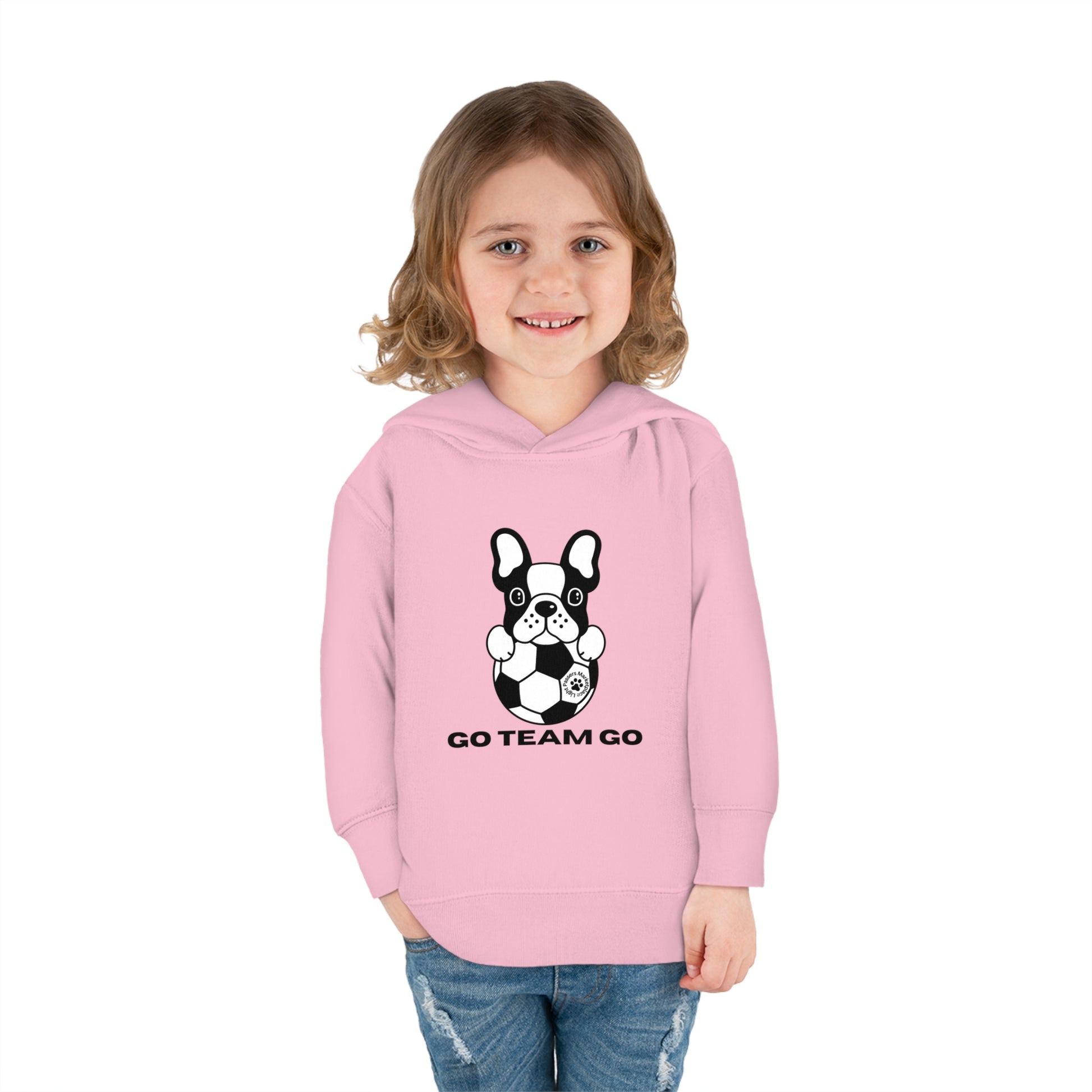 A toddler hoodie featuring a girl in a pink sweatshirt with a dog design, embodying comfort and durability with cover-stitched details, side seam pockets, and a cozy hood.