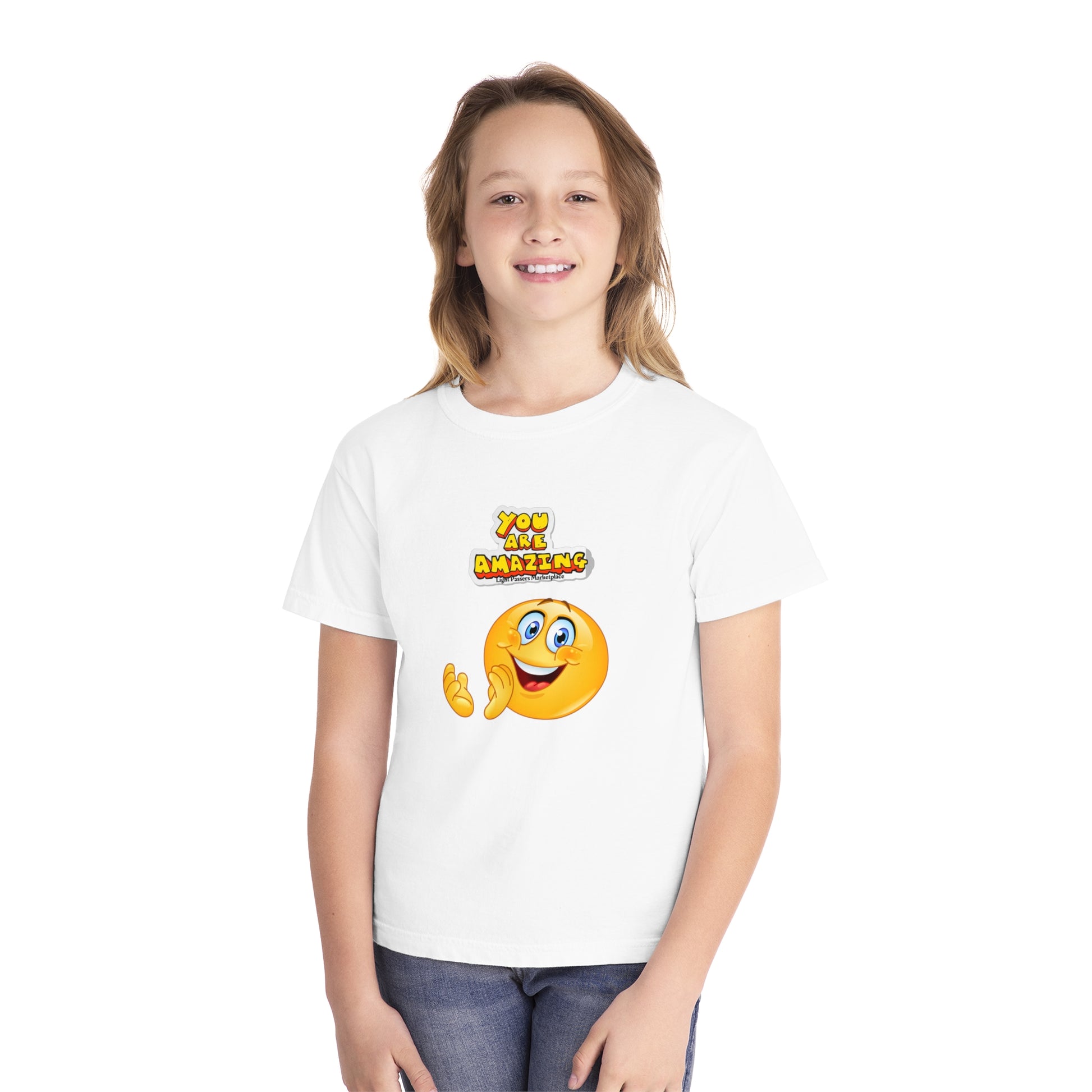 A girl in a white shirt smiles at the camera, showcasing the You are Amazing Clap youth t-shirt. Made of 100% combed ringspun cotton for comfort and agility, perfect for kids' active days.