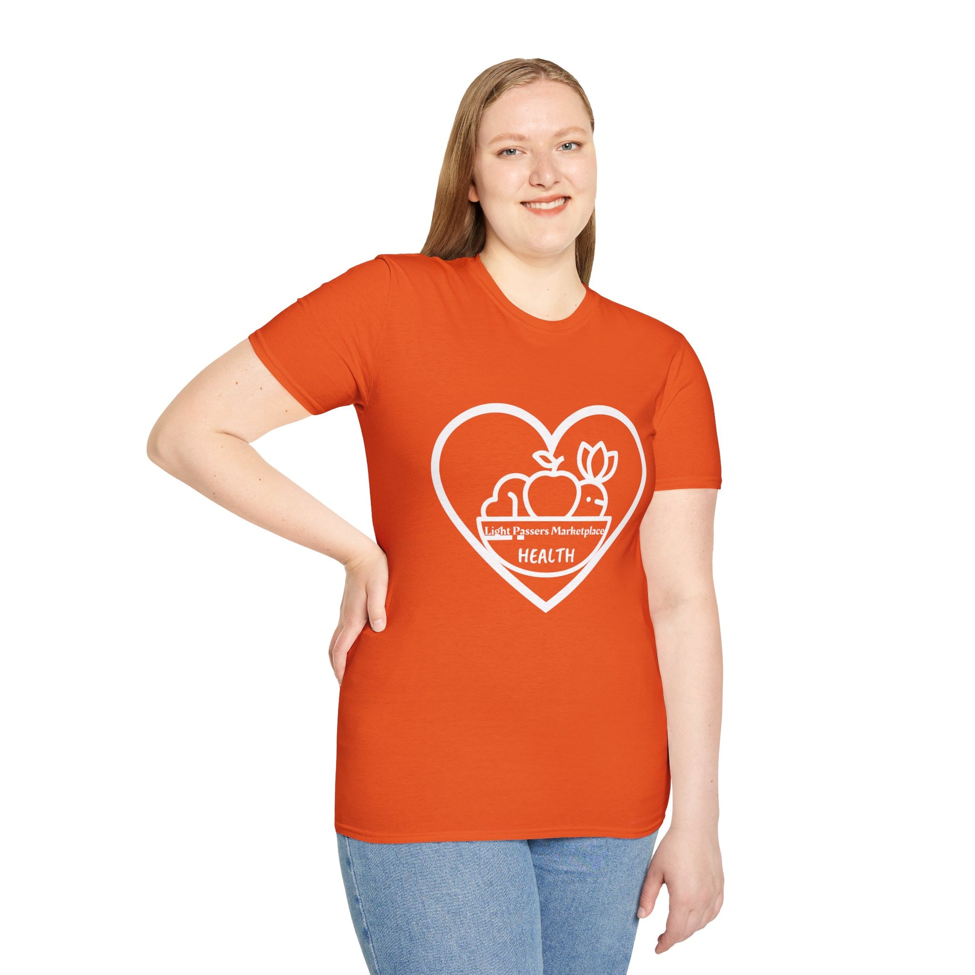 A woman in an orange shirt, smiling, showcasing the Light Passers Marketplace Fruit Basket Unisex T-Shirt. Close-up of shirt details and blue jeans. Ethically made, 100% cotton tee with ribbed collar and tear-away label.