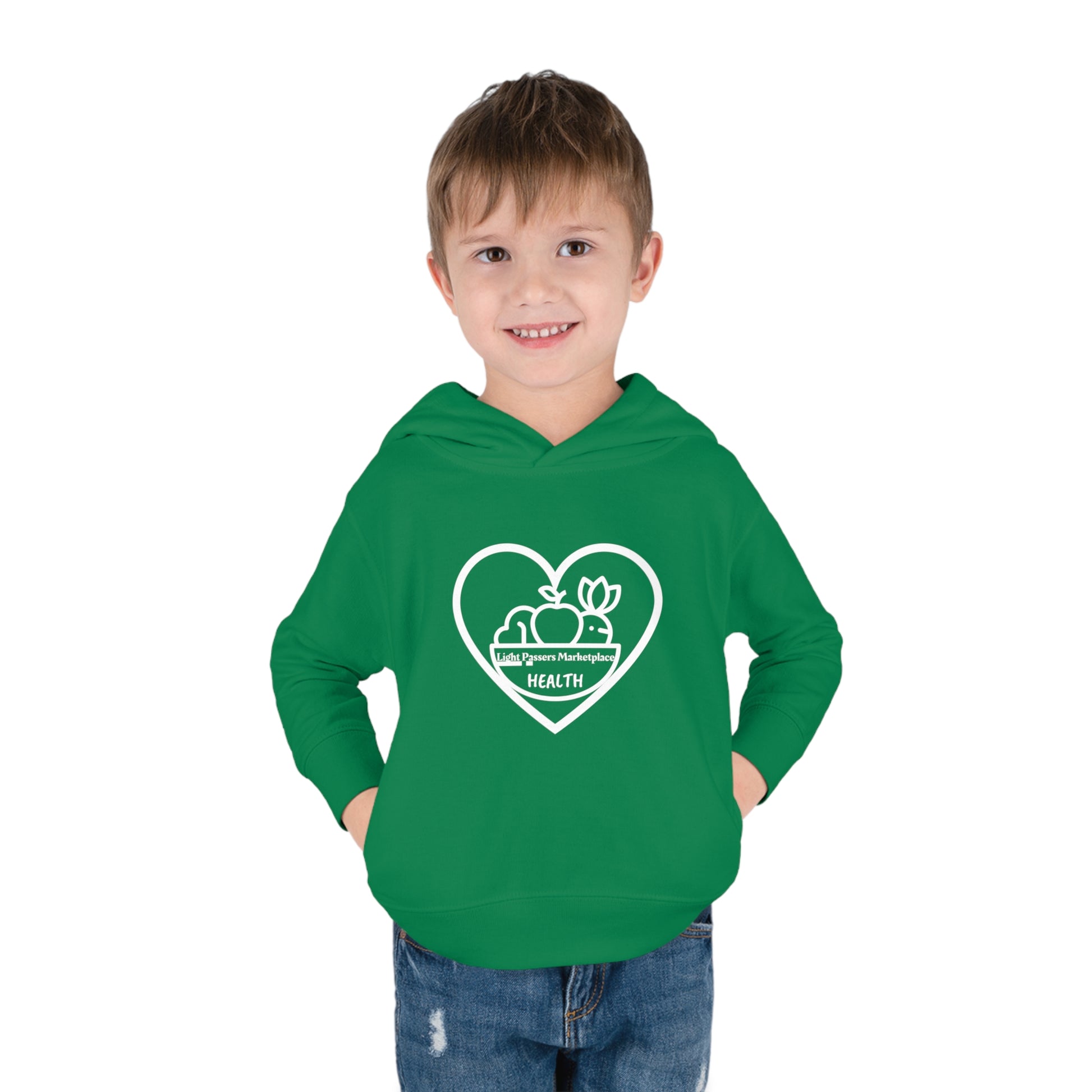 A toddler wearing a green Fruit Basket Toddler Hoodie with a heart and logo, featuring side seam pockets and double-needle hemmed details for durability and comfort.
