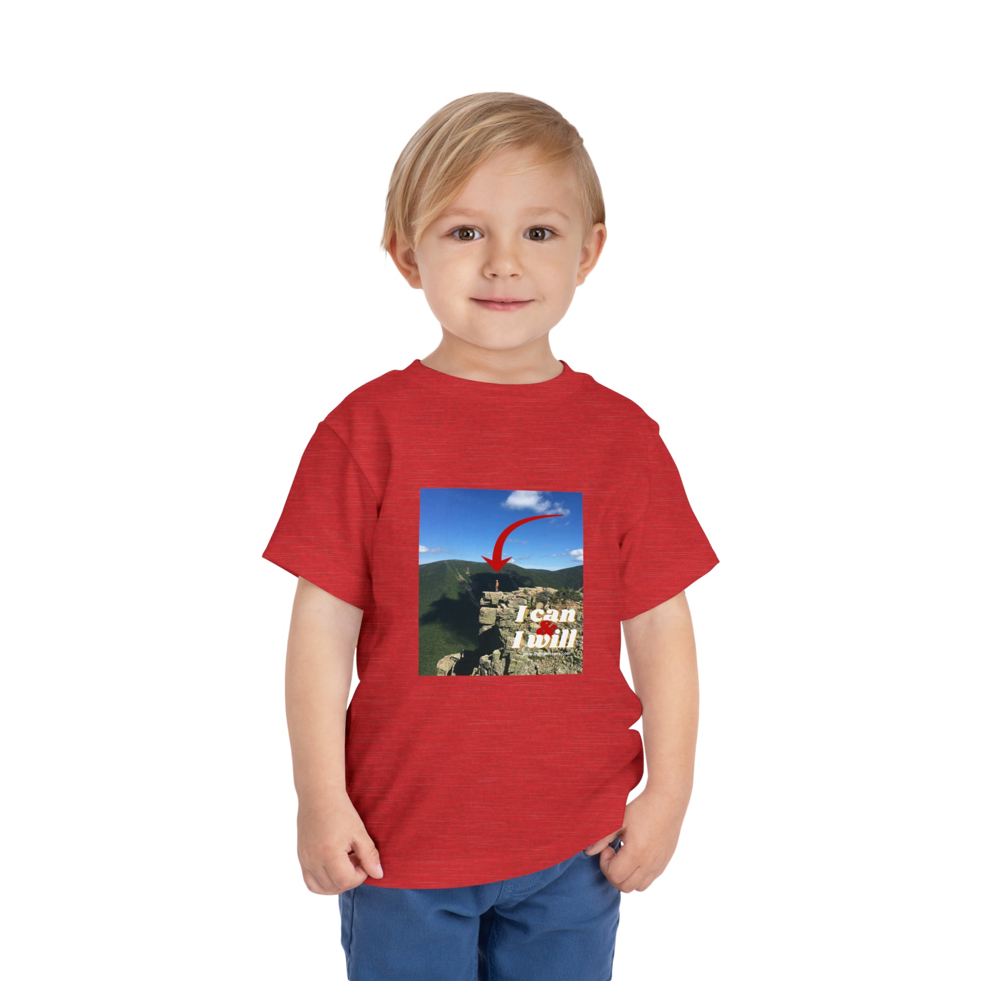 A determined boy in a red I Can and I Will Hiking toddler t-shirt, standing confidently. Made of 100% Airlume combed cotton for comfort.