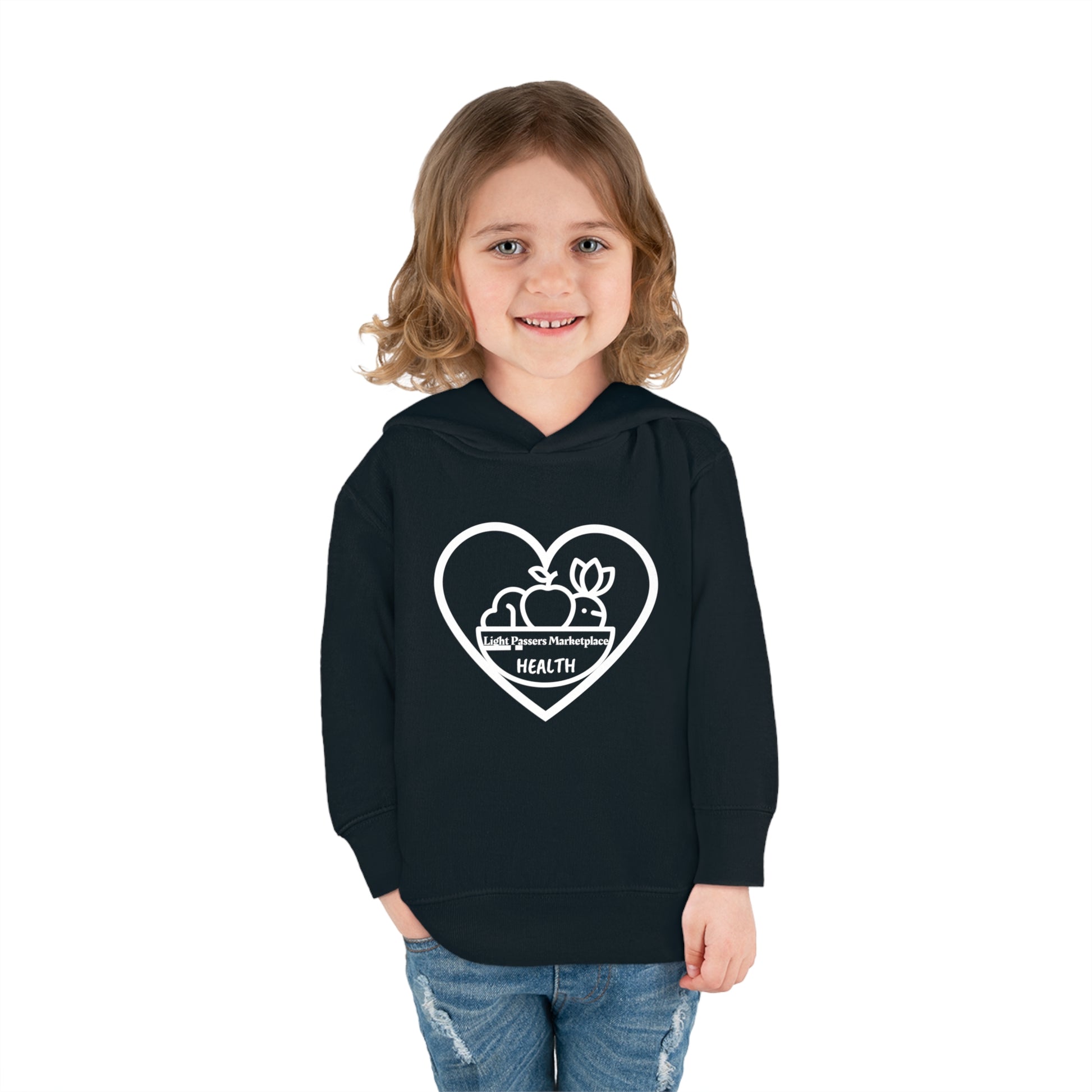 A smiling child in a black sweatshirt with a heart logo, showcasing a Fruit Basket Toddler Hoodie. Features jersey-lined hood, side pockets, and durable stitching for lasting coziness.