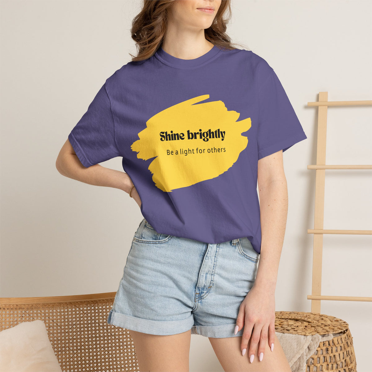 Unisex T-shirt in grape purple worn by adult model with yellow chest graphic