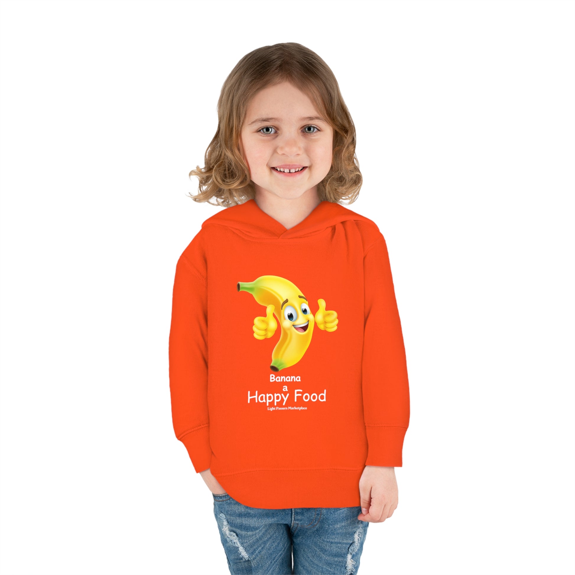 A smiling toddler in an orange cartoon character hoodie with a thumbs-up banana design. Features jersey-lined hood, cover-stitched details, side seam pockets, and durable cotton-polyester blend for cozy wear.