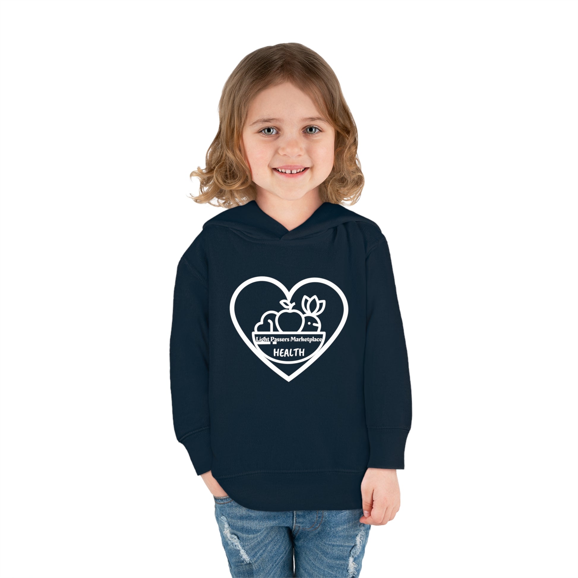 A smiling child in a Fruit Basket Toddler Hoodie, featuring a heart and fruit logo. Jersey-lined hood, cover-stitched details, side-seam pockets for cozy durability.