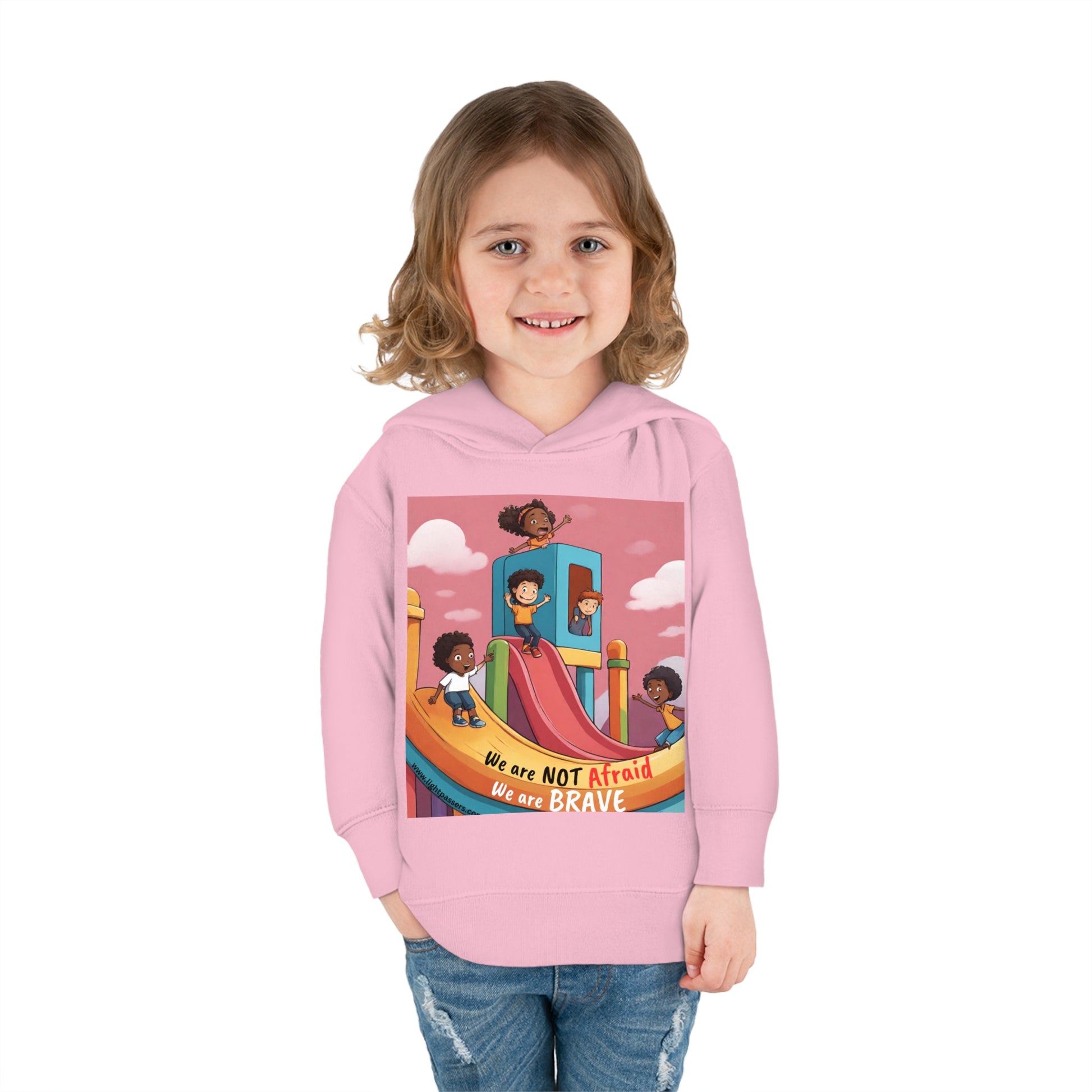 A smiling girl in a Rabbit Skins toddler hoodie with a slide design, showcasing comfort with jersey-lined hood, cover-stitched details, and side seam pockets for lasting coziness.