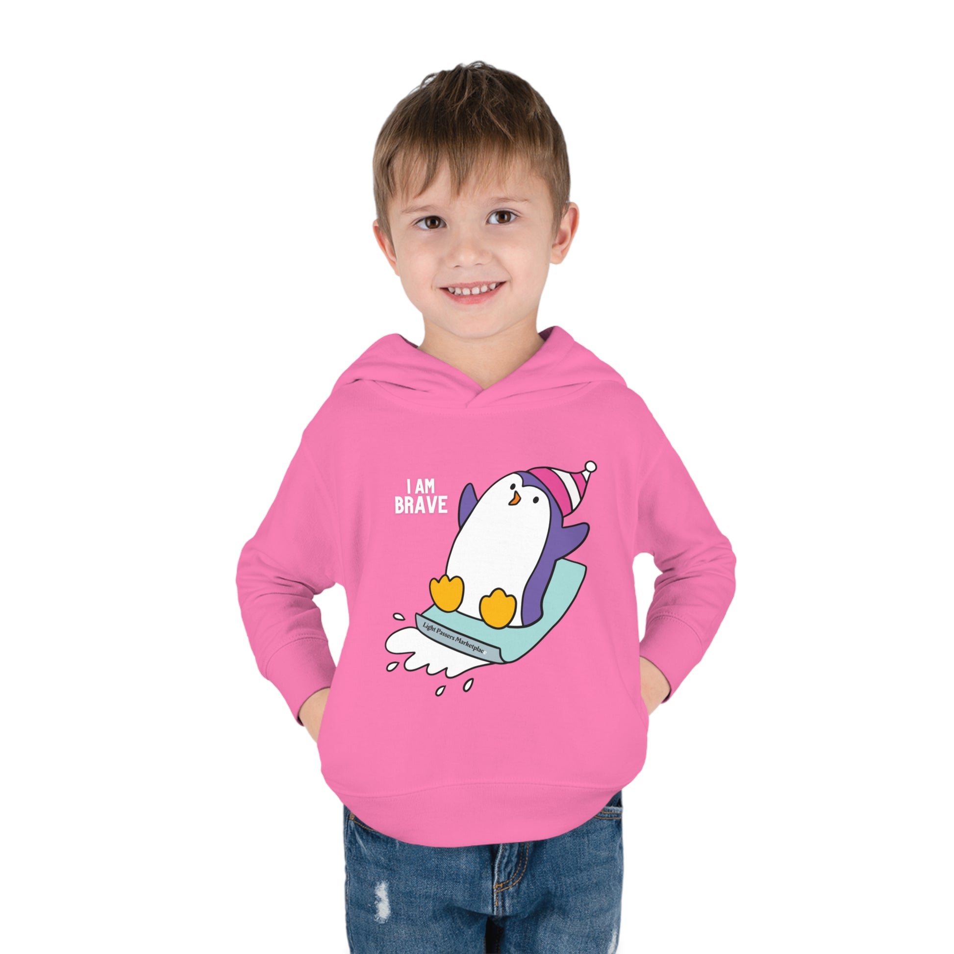 A toddler in a pink hoodie with a playful penguin design, showcasing cover-stitched details, side seam pockets, and a durable double-needle hem hood for lasting comfort.